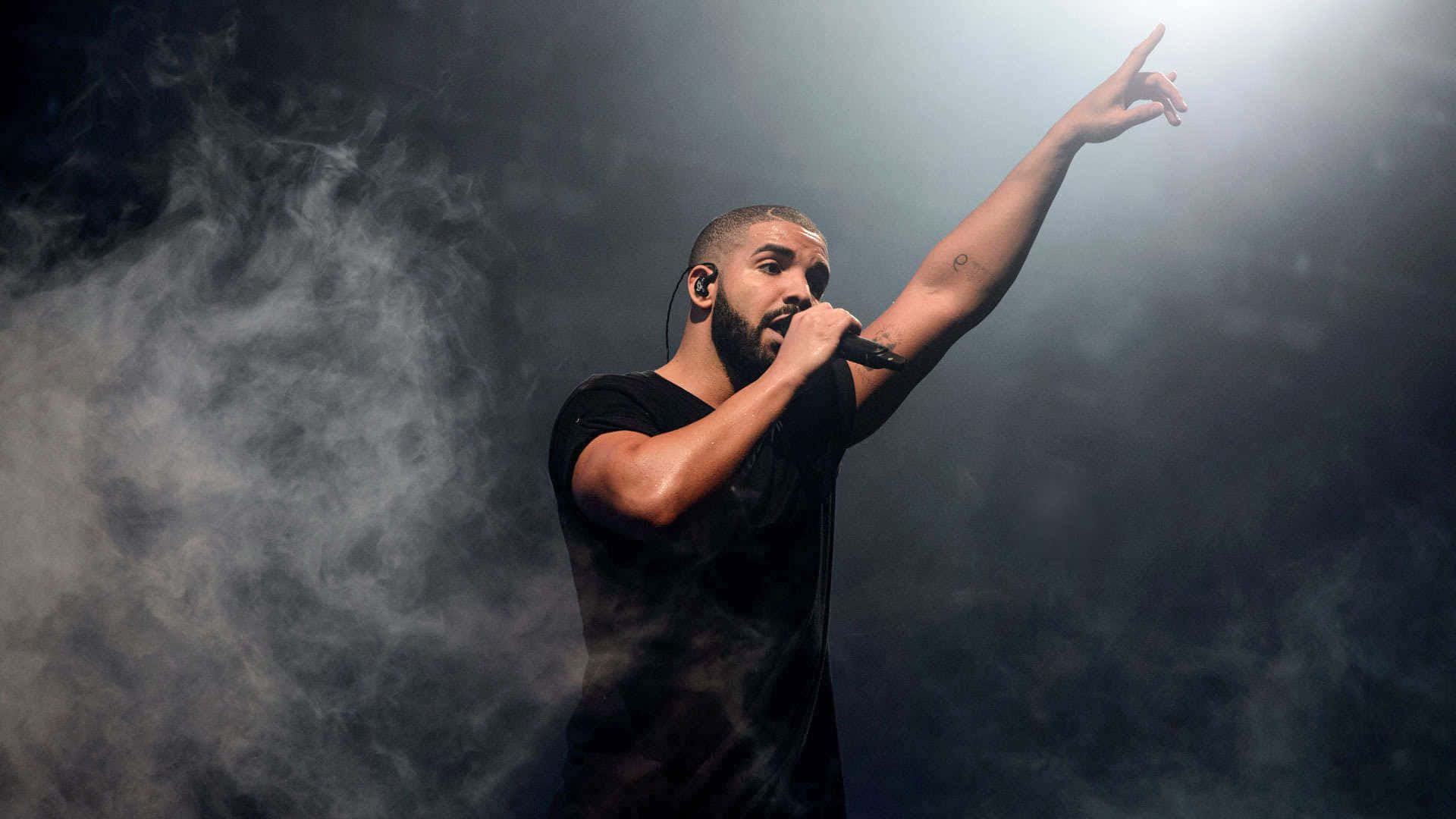 Drake, posing confidently in a live concert
