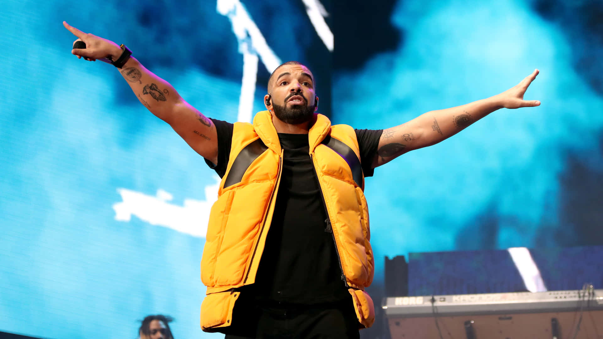 Drake Performs At A Concert With His Arms Outstretched Wallpaper