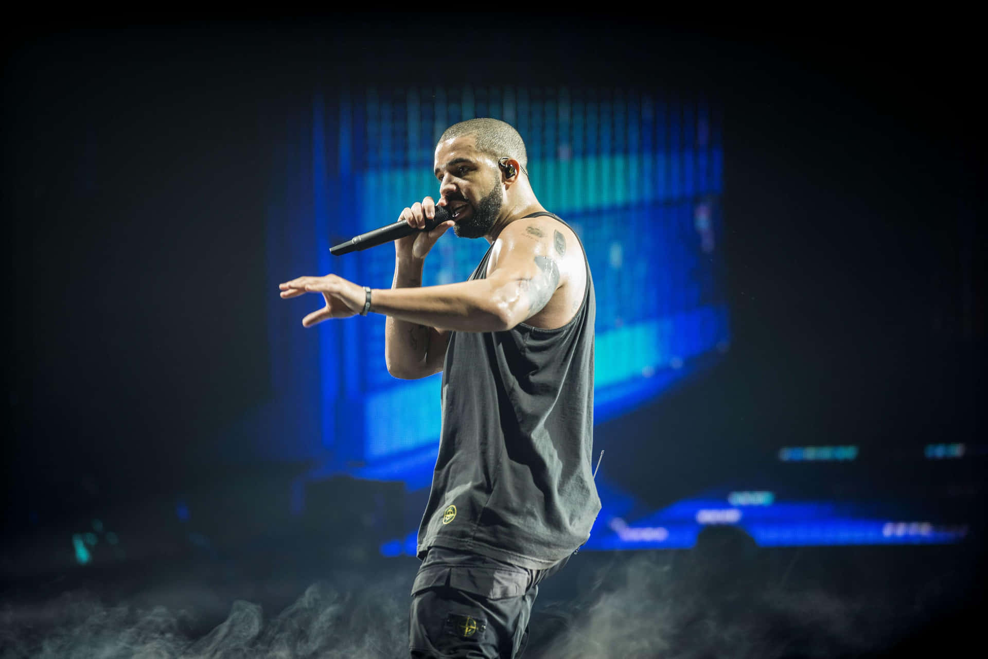 Drake optræder på scenen i et rygerigt arena. Wallpaper