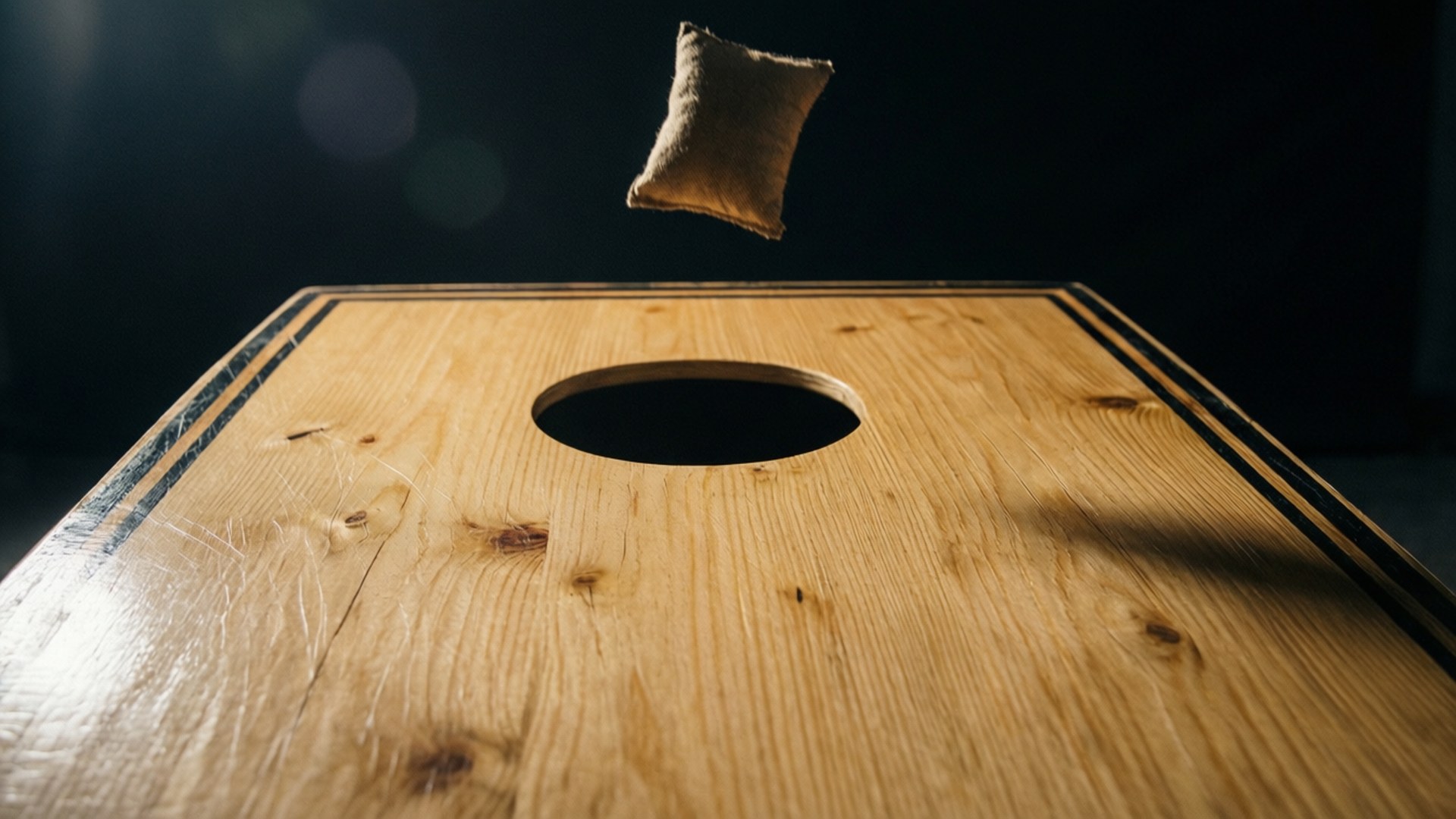 En dramatisk närbild av en bönpåse på väg mot en cornhole-bräda.