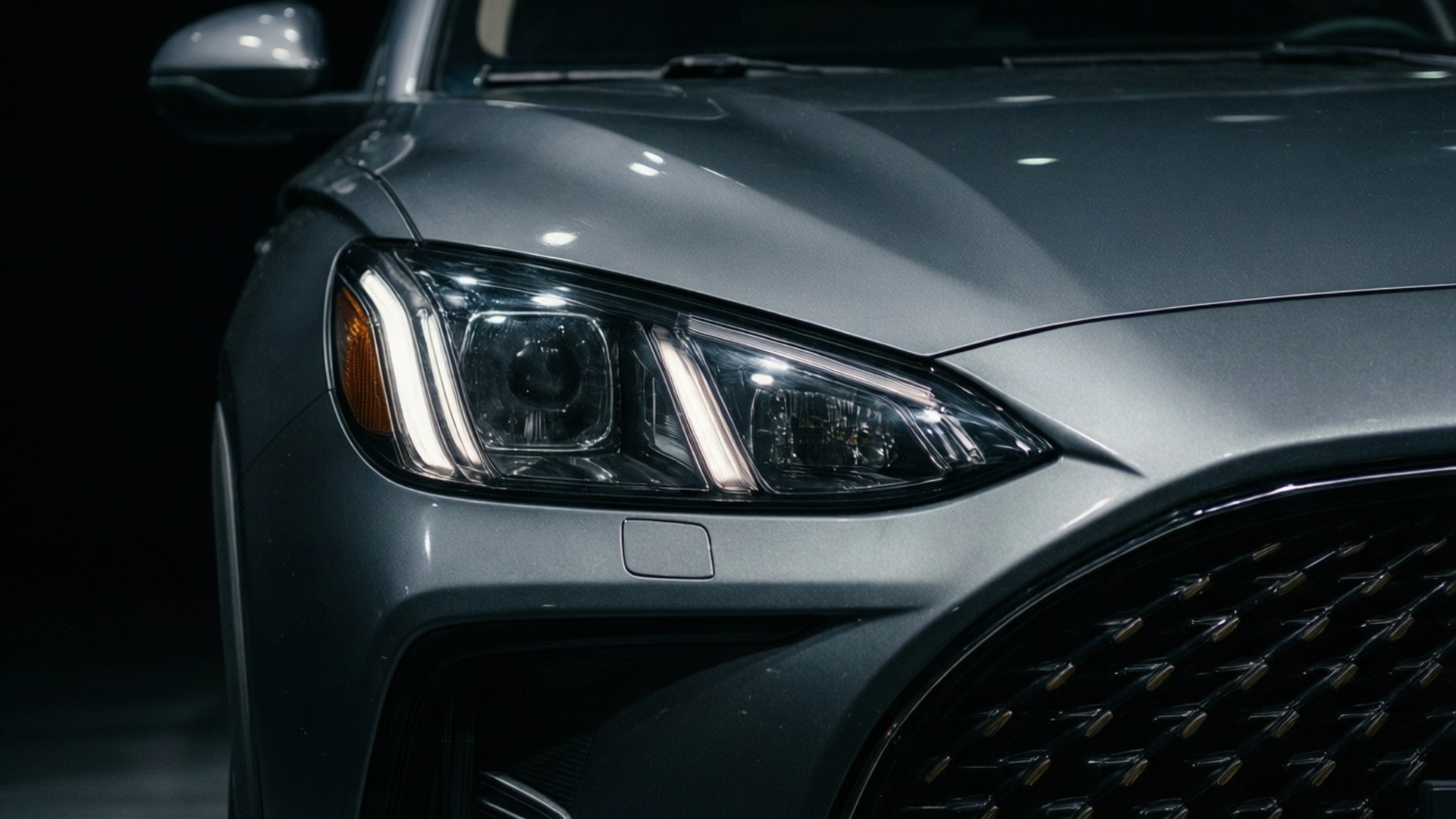 MG5 car front close-up with dramatic lighting and dark background.