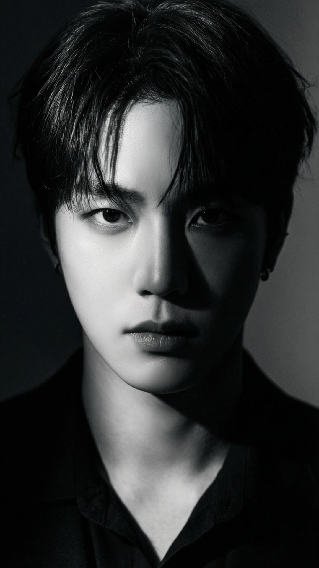 Dramatic Shadow Portrait Wallpaper — A moody black and white portrait of a young man with intense gaze and dramatic lighting.