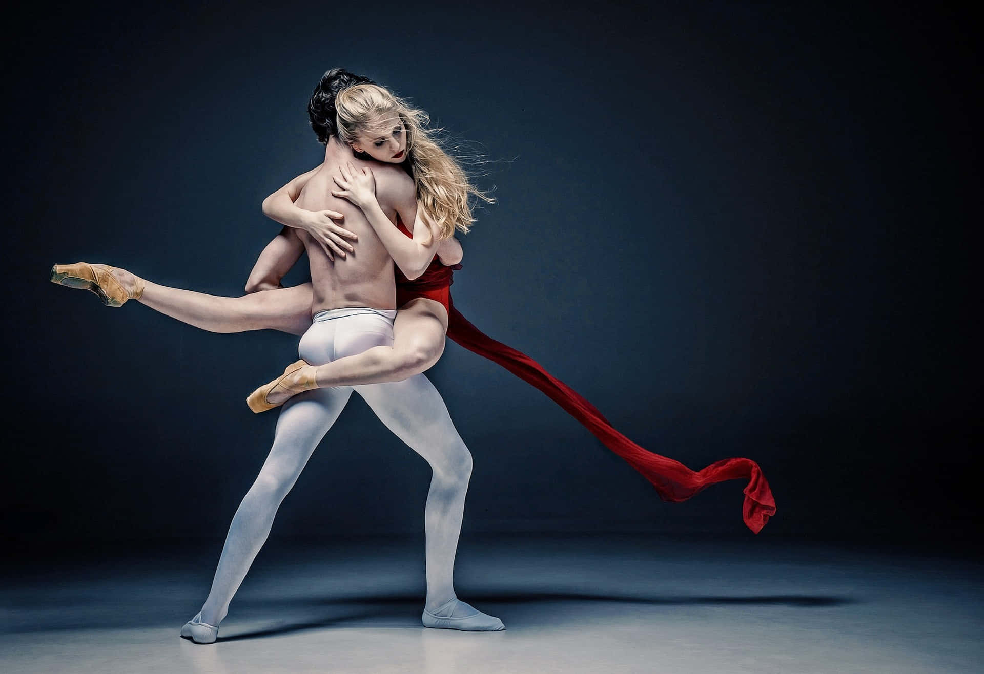 Dramatic Shot Of Two Dancers' Tangible Embrace On Black Background Wallpaper