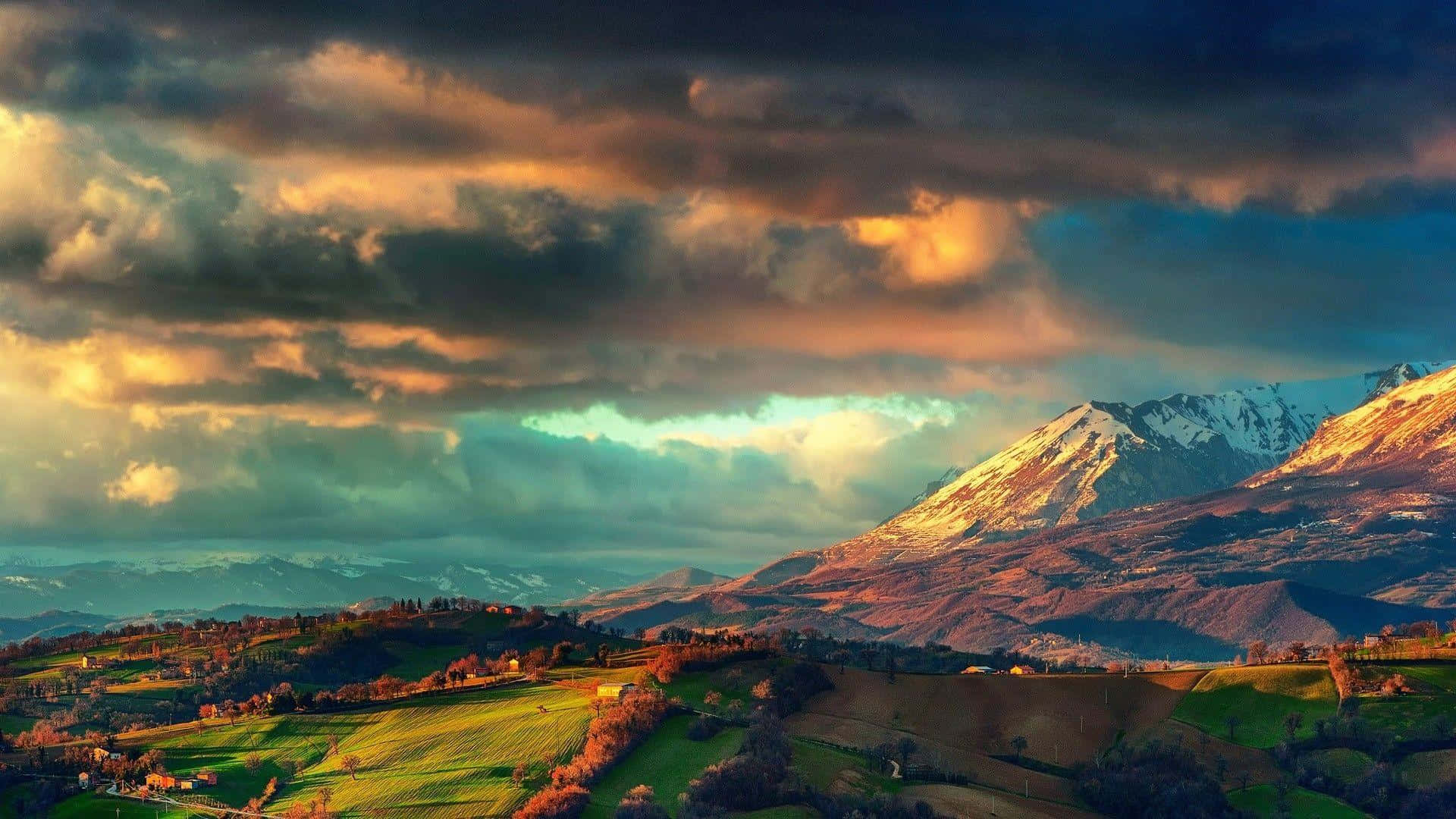 Dramatic_ Sunset_ Over_ Snow_ Capped_ Mountains Wallpaper