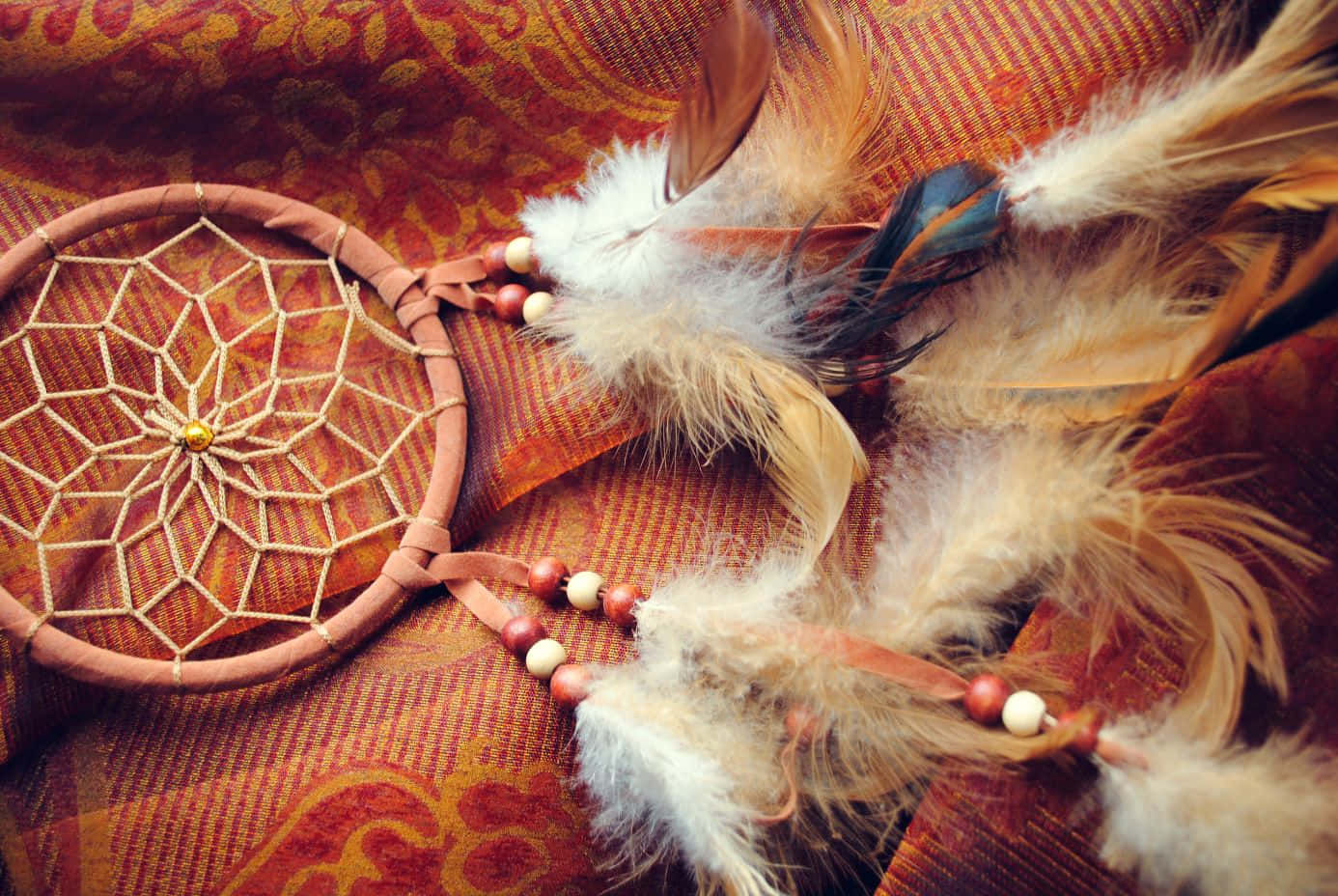 A Dream Catcher On A Red And Brown Cloth