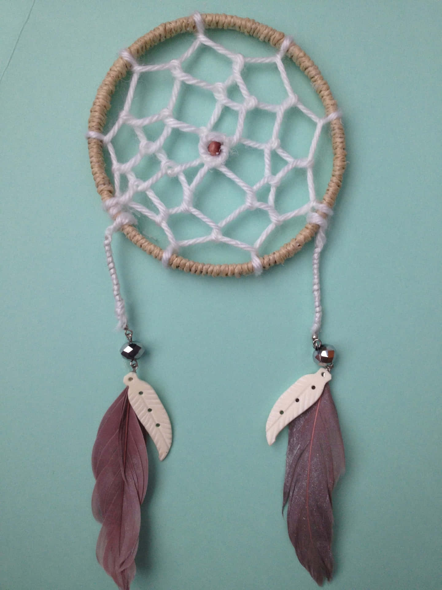 A Dream Catcher With Feathers Hanging On It