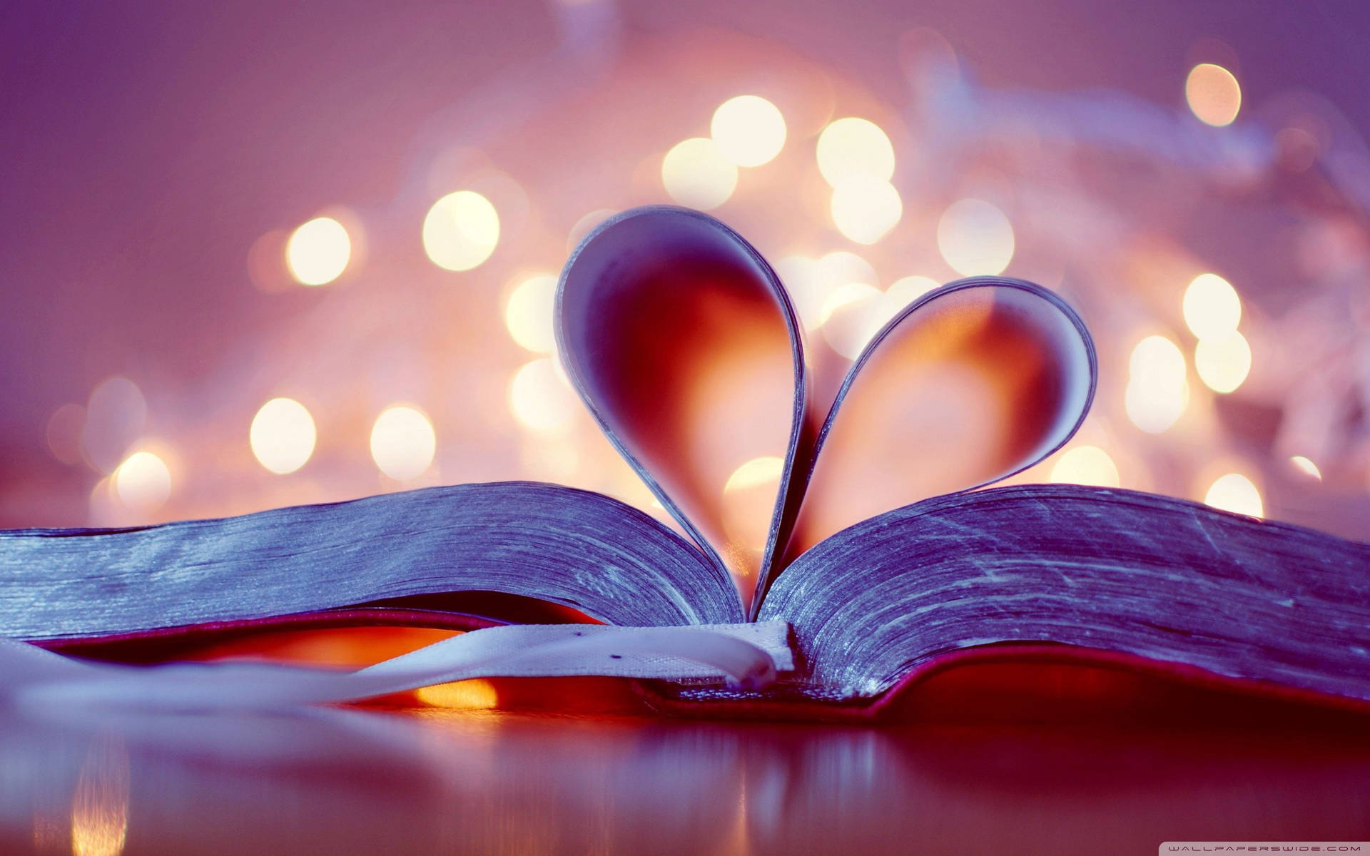 Dreamy lights and heart-shaped pages of a book wallpaper