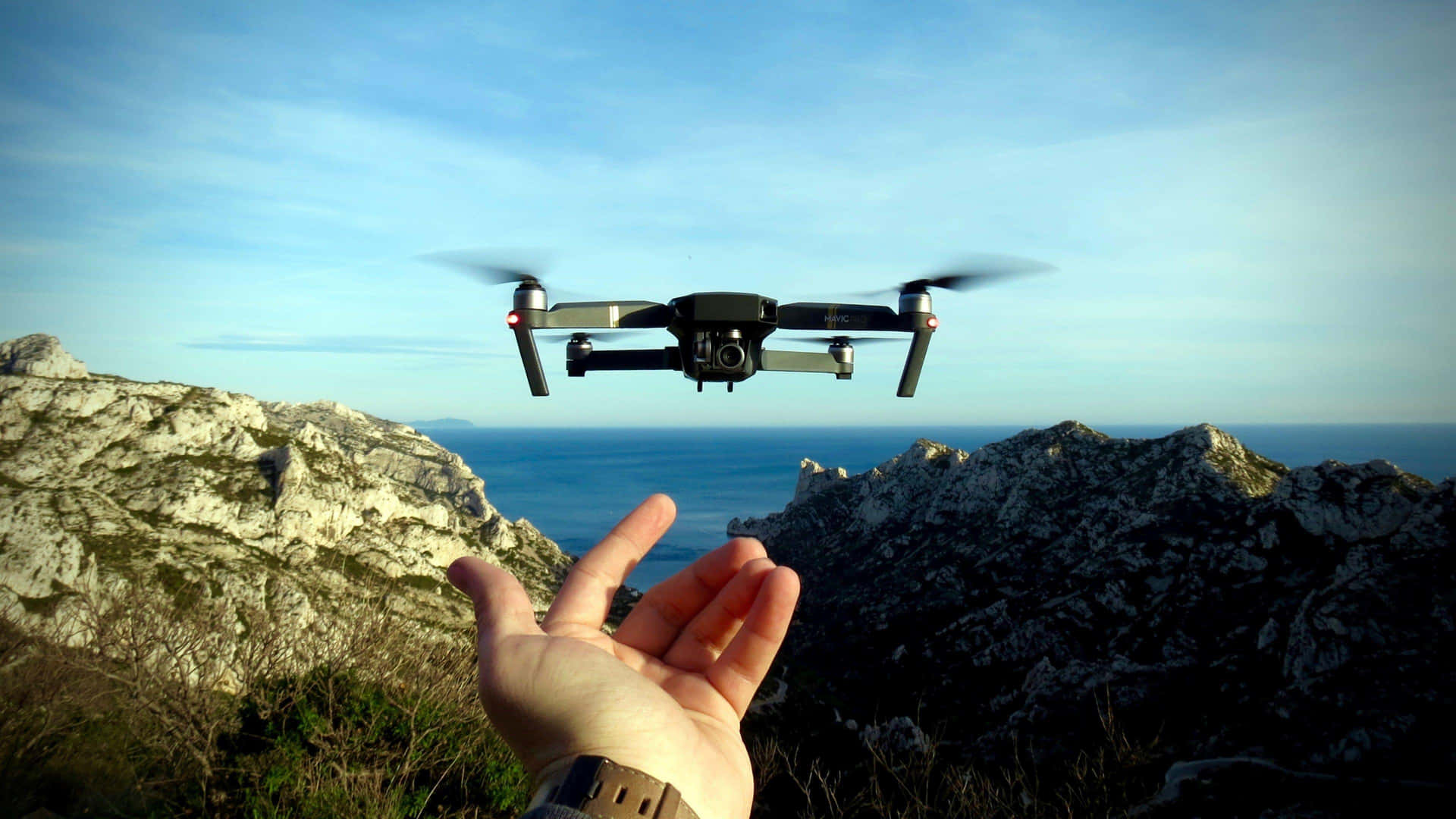 Drone In Flight Over Mountainous Terrain Wallpaper