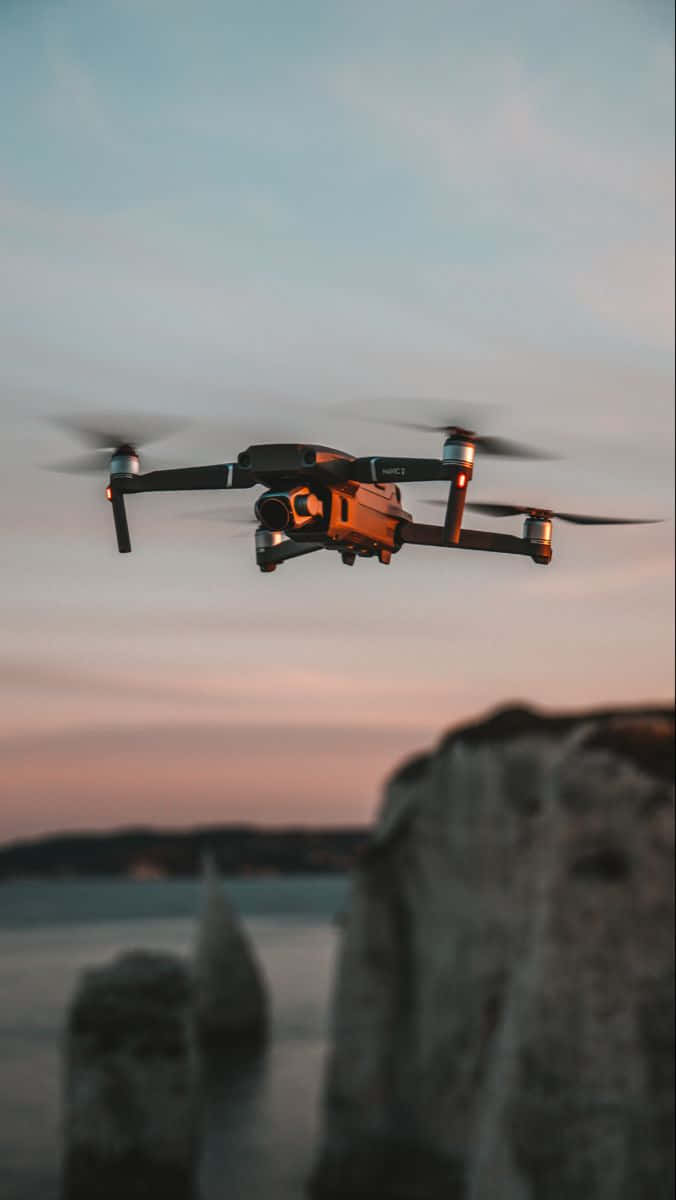 A Drone Flying Over A Cliff And Ocean