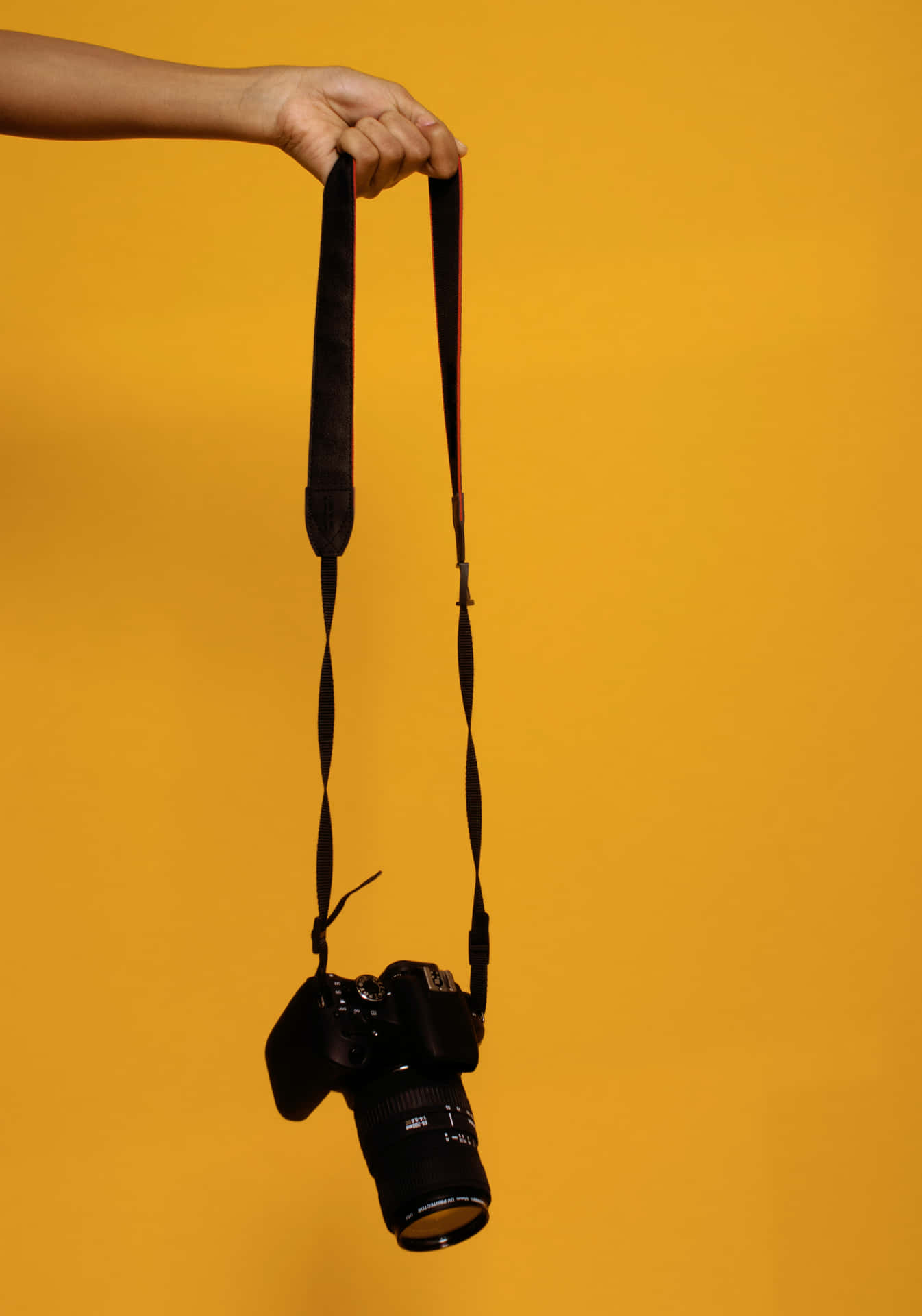 DSLR Camera With Strap Yellow Background