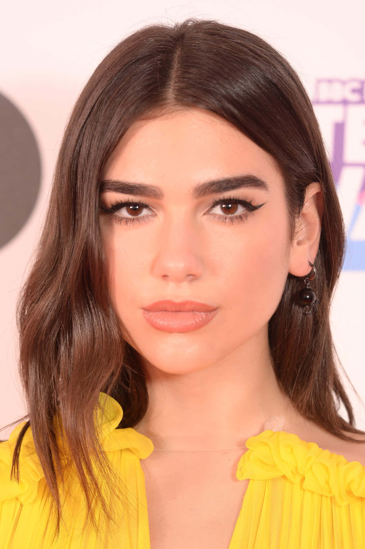 Dua Lipa radiates with style wearing her signature colorful makeup