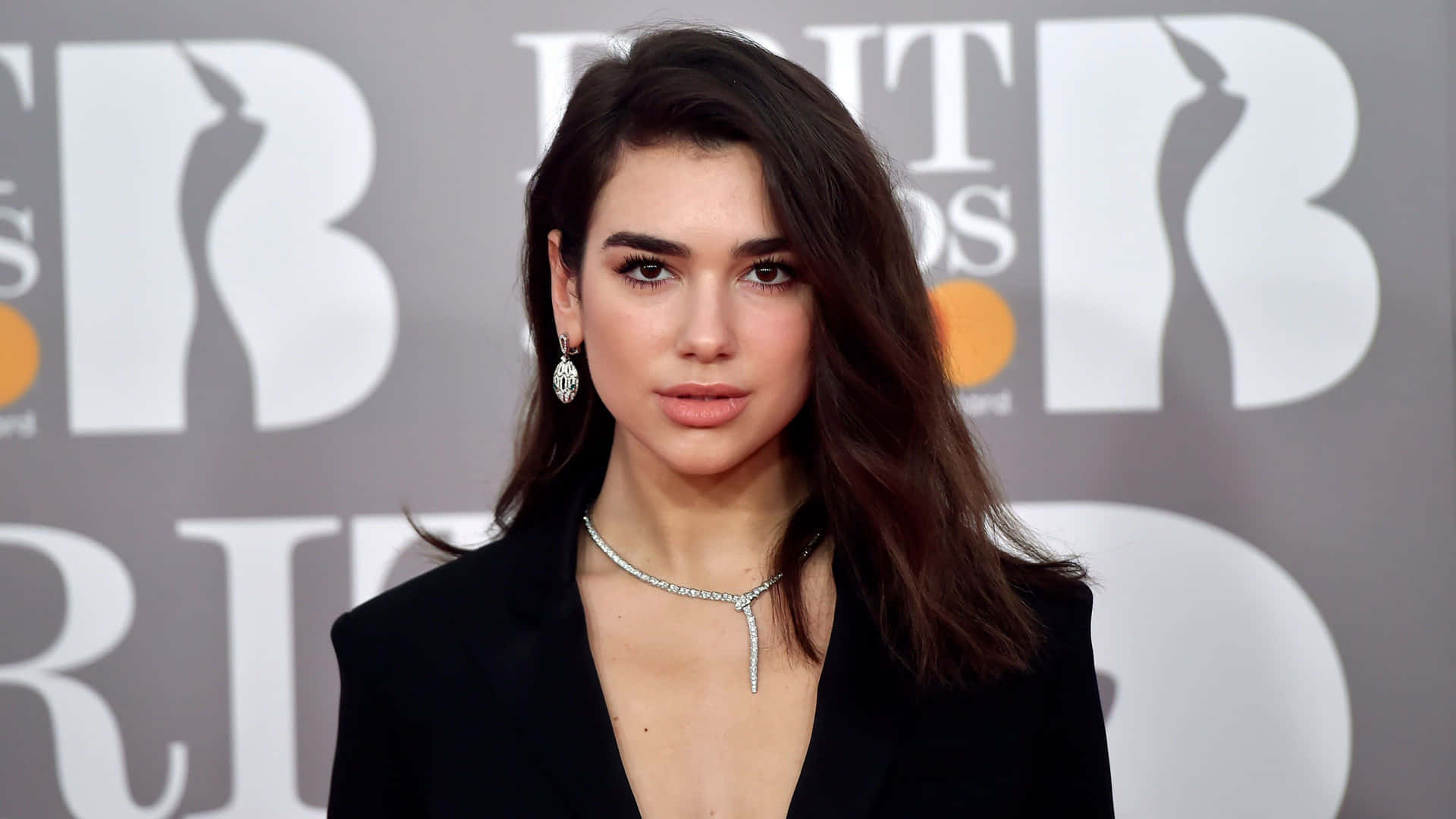 Dua Lipa posing in a stylish outfit during a photoshoot