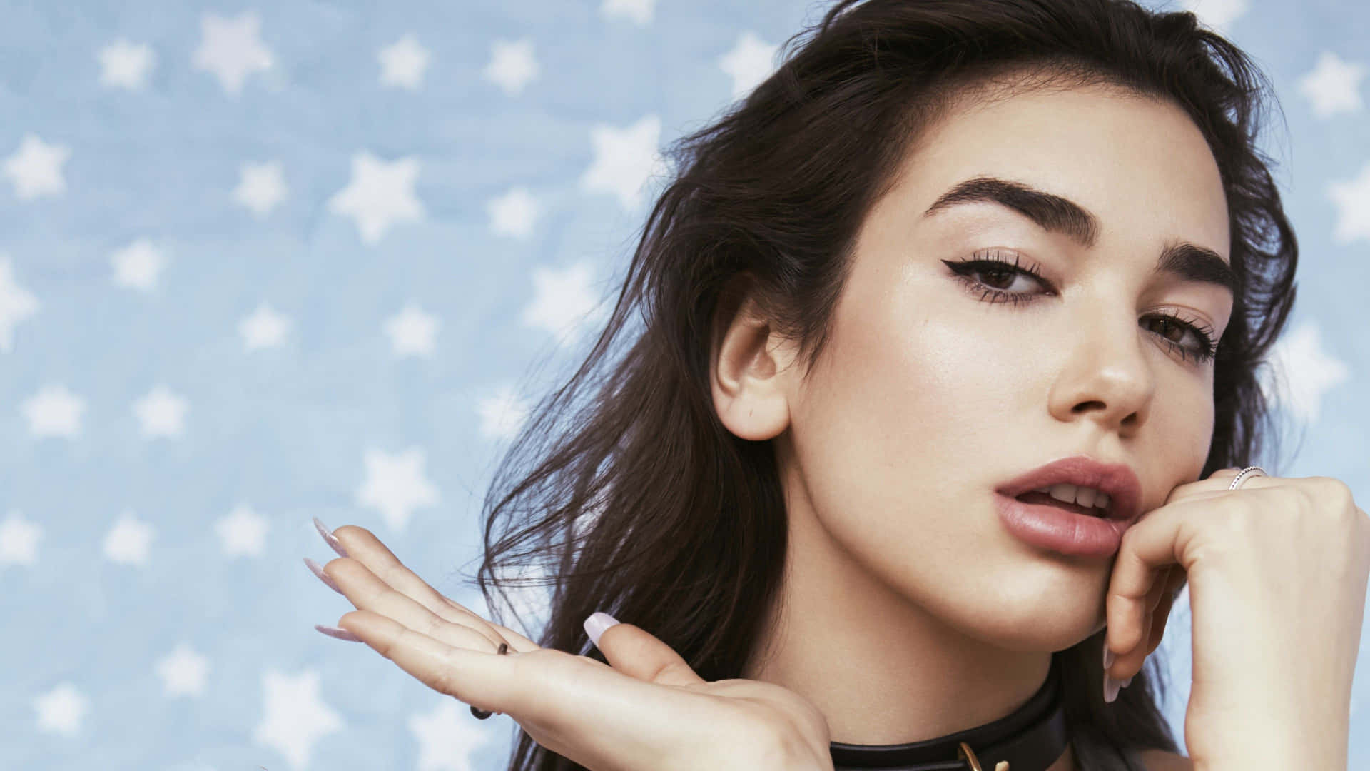 Dua Lipa striking a pose on stage during a live performance