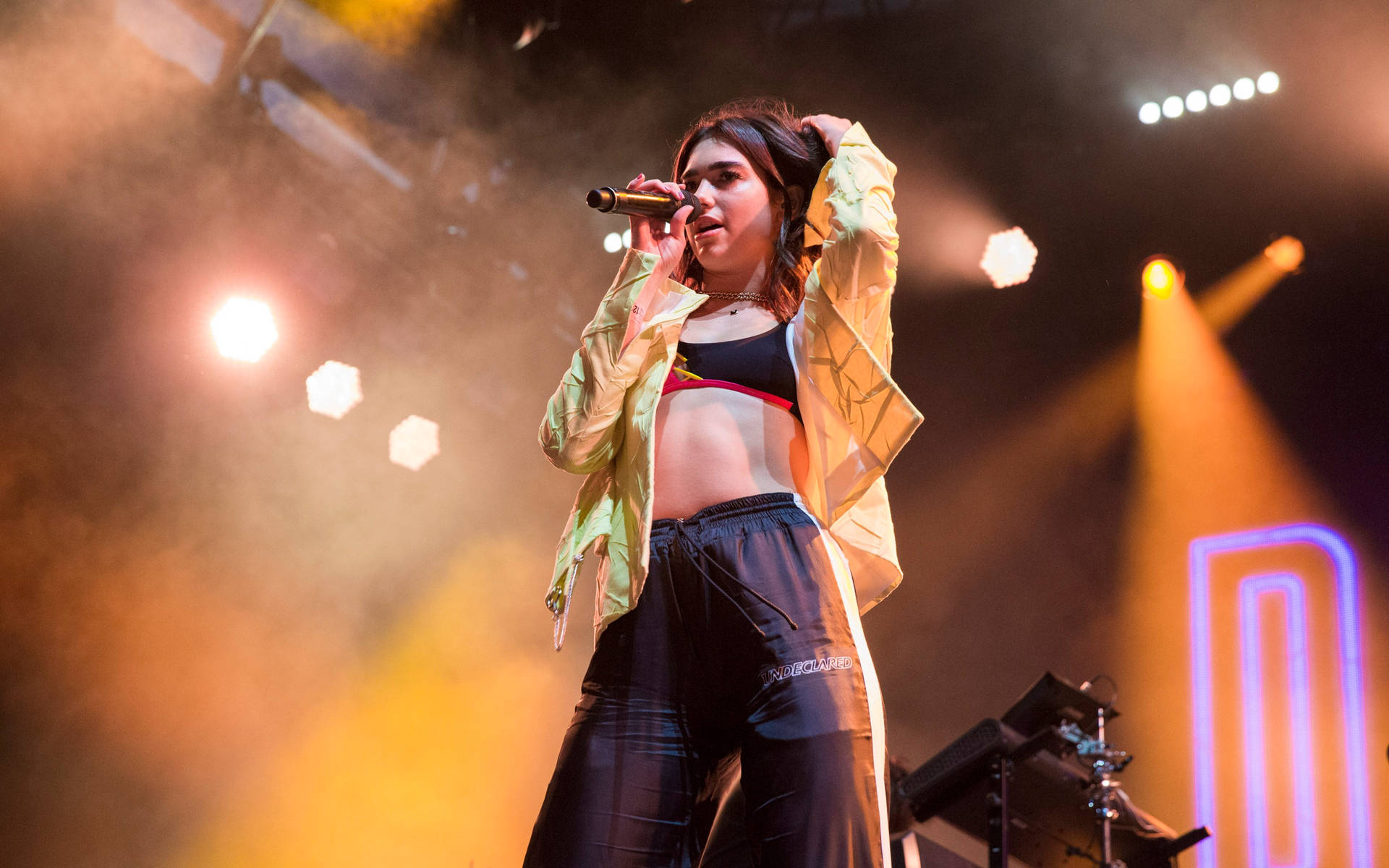Dua Lipa Performing On Stage Background