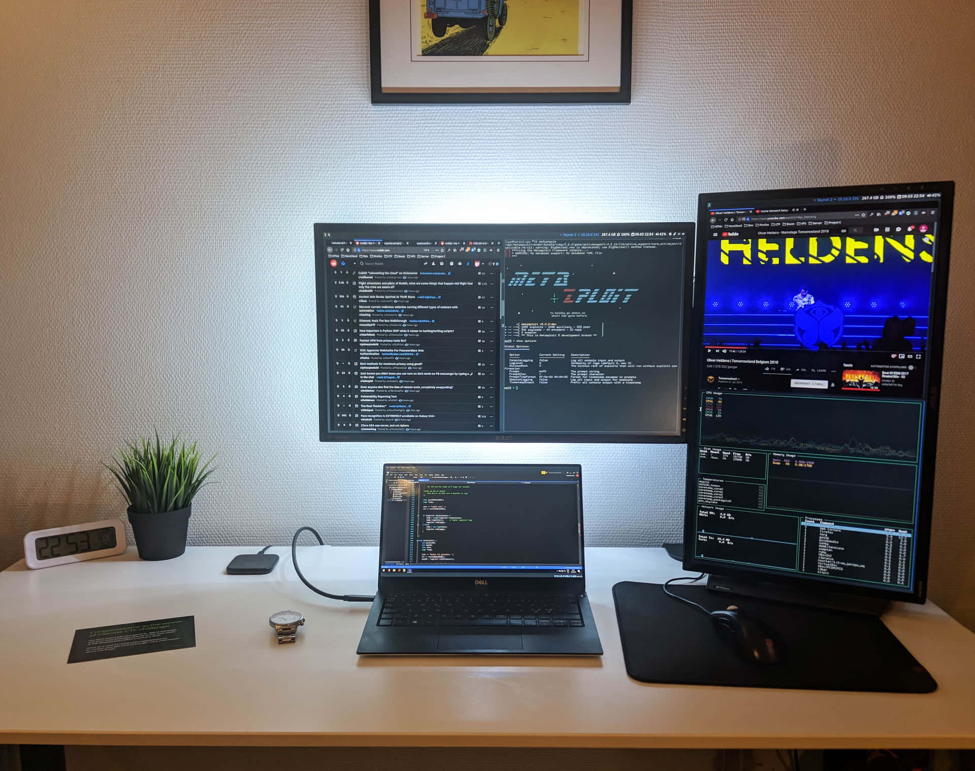 Et skrivebord med to skærme og en bærbar computer.