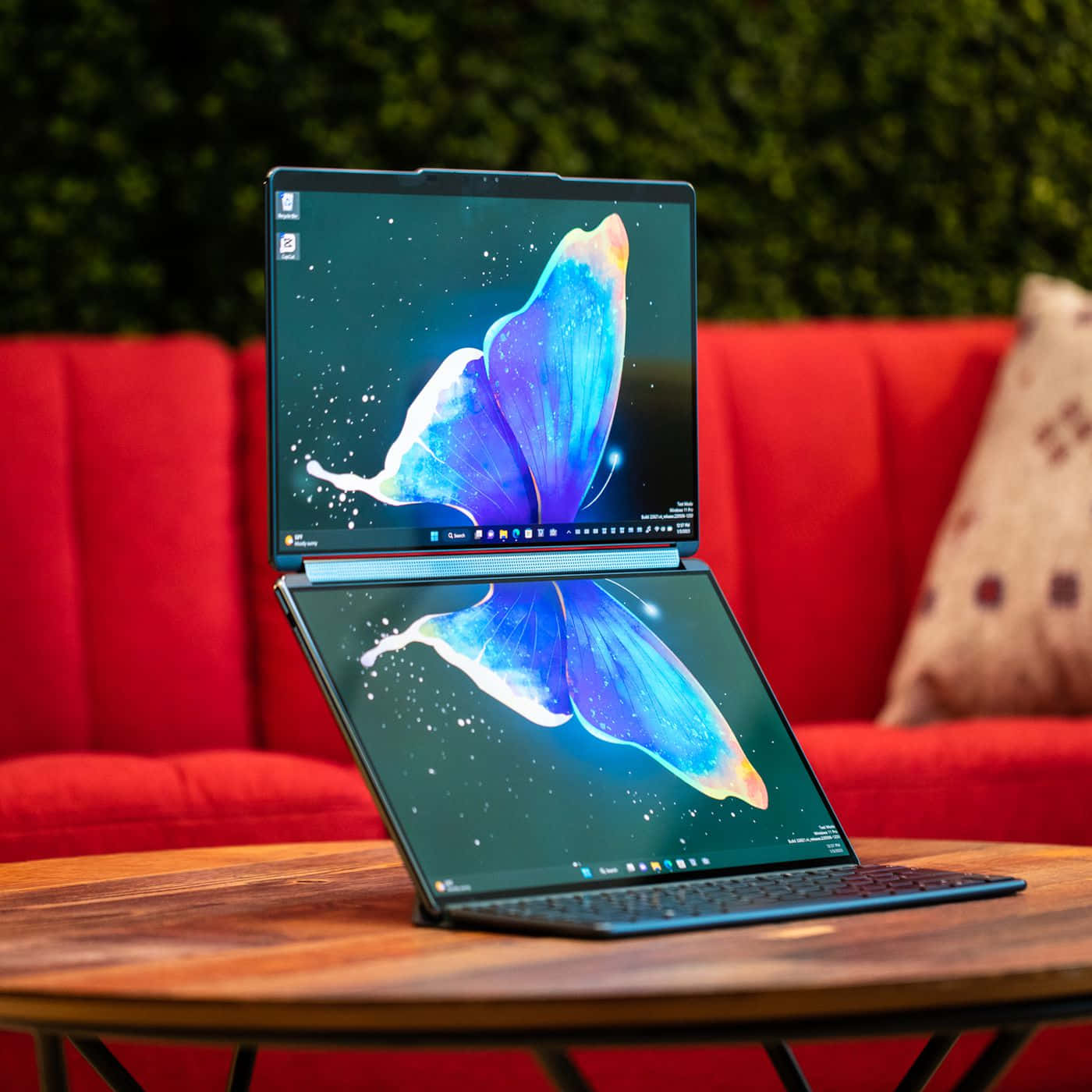 Et laptop med en sommerfugl på det, der sidder på et bord.