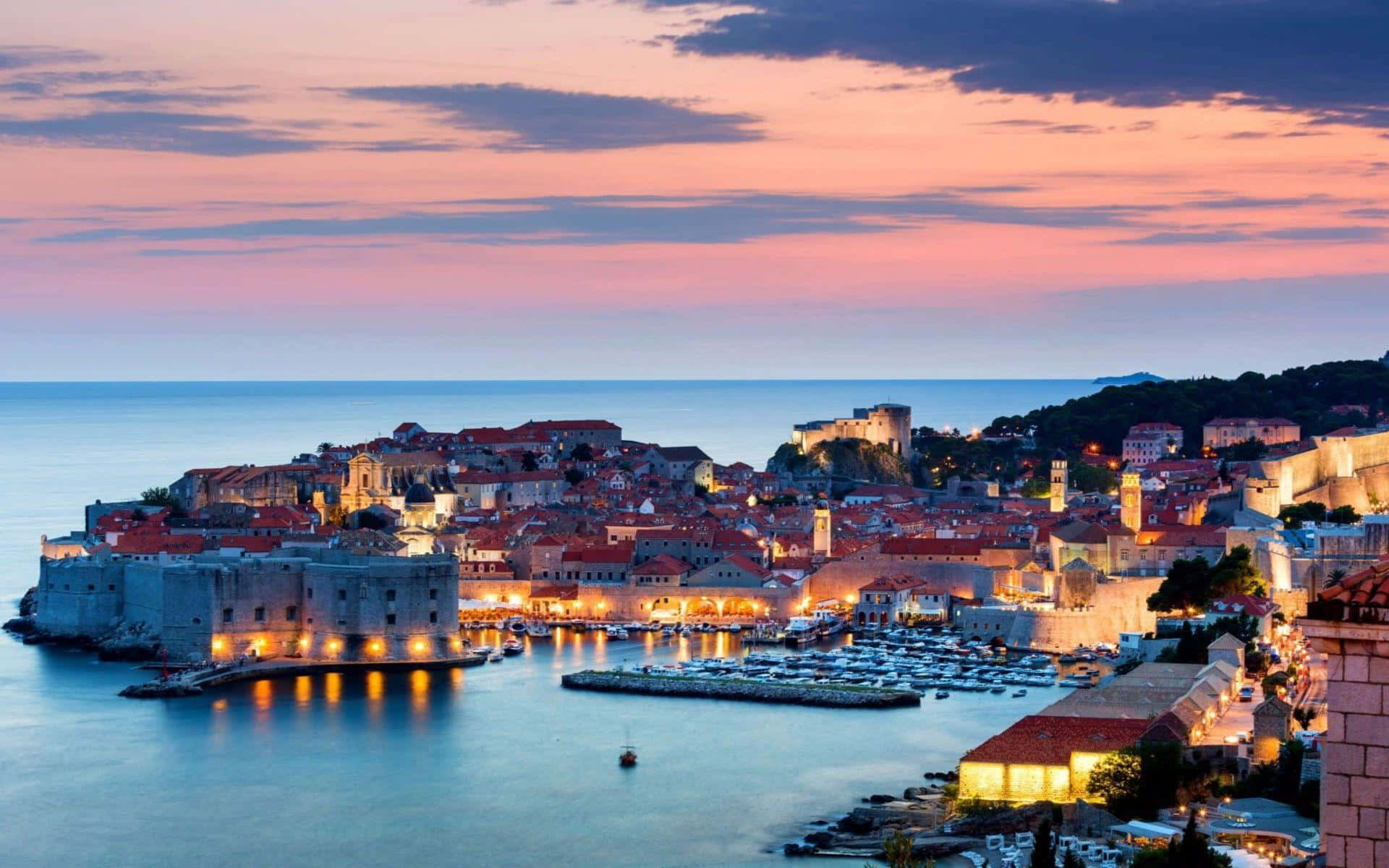 Dubrovnikilluminata Dalle Luci Arancioni Della Città Sfondo