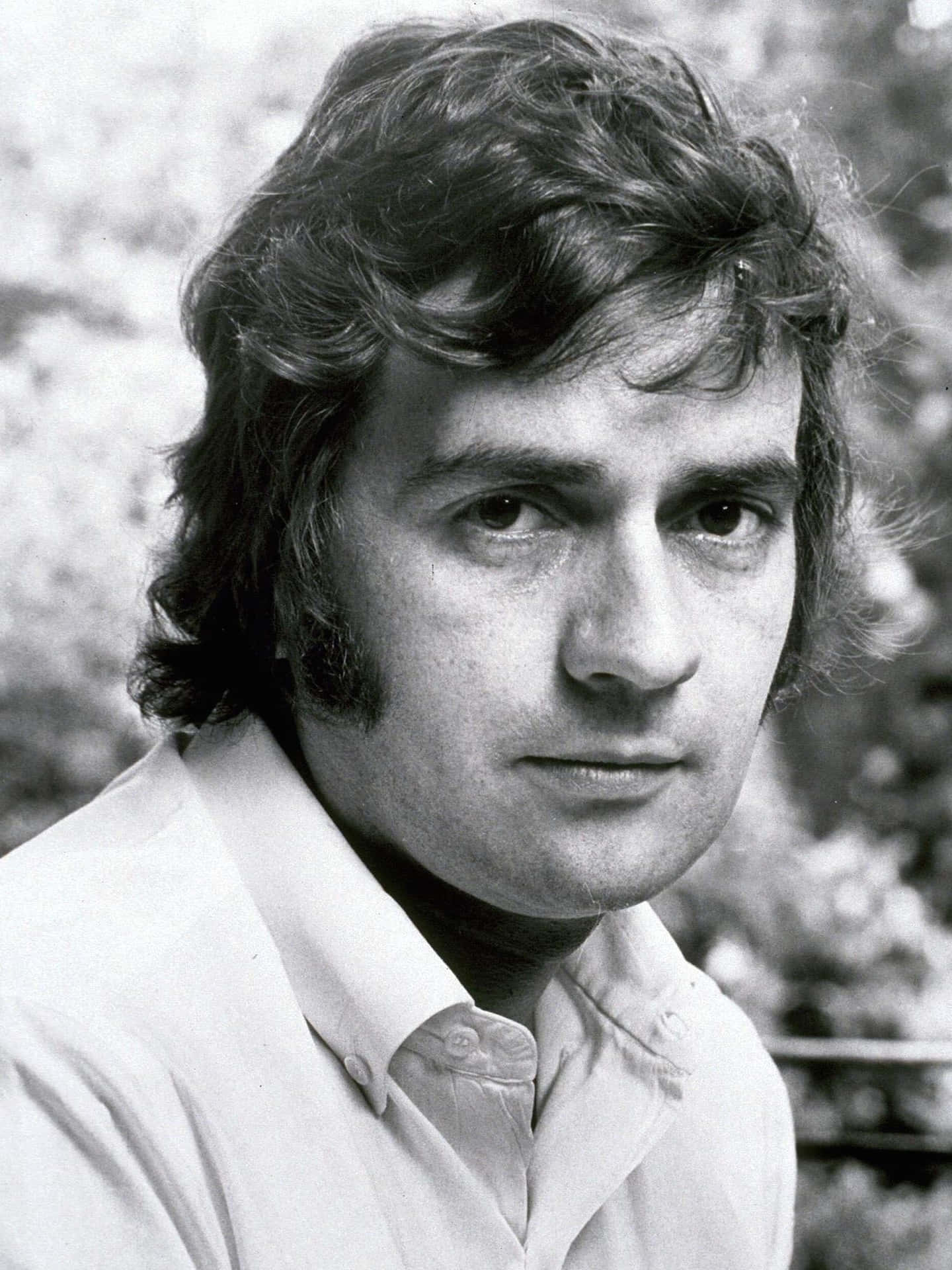 Caption: Renowned English actor and comedian Dudley Moore posing for a portrait Wallpaper
