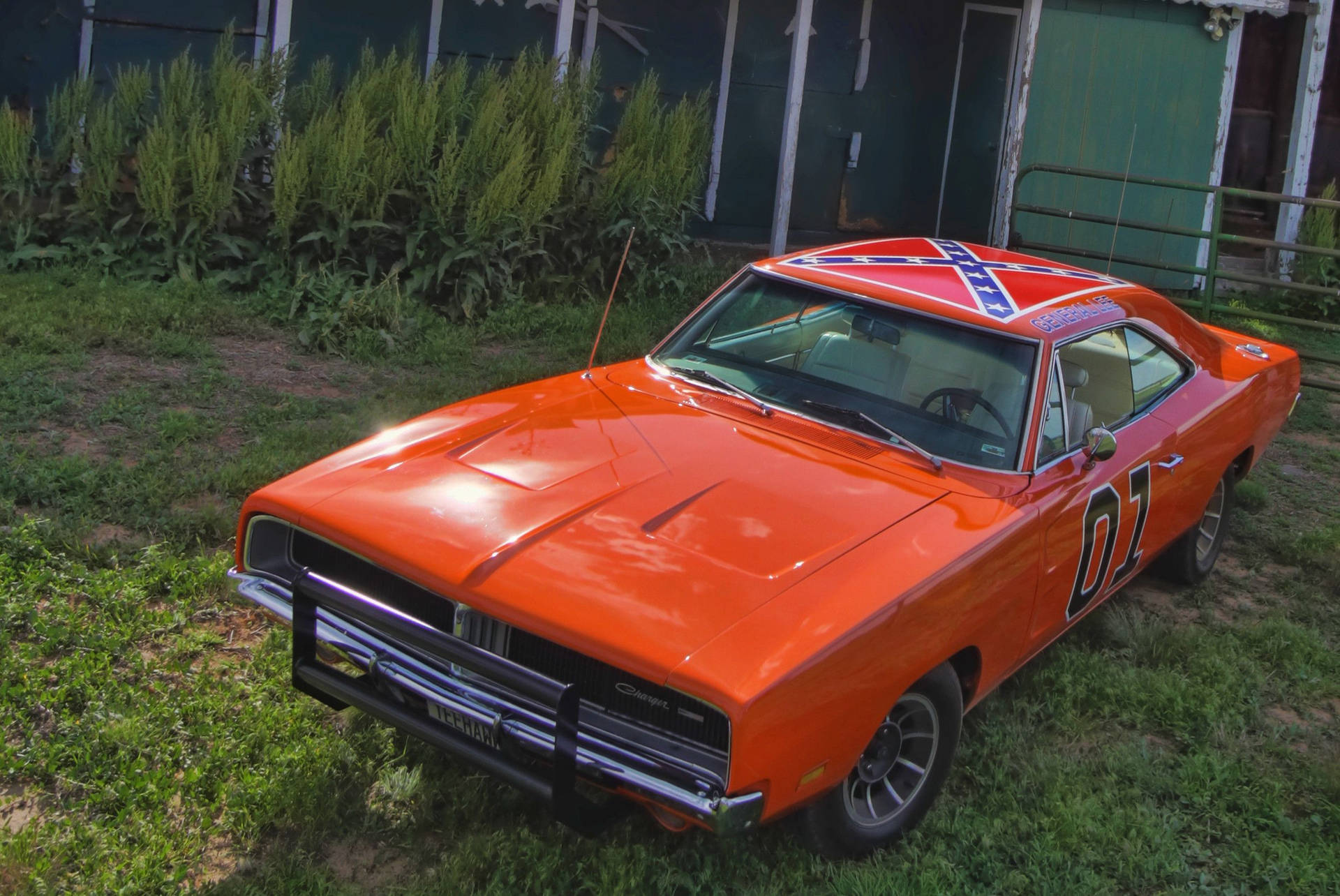 En orange Dodge Charger parkeret i græsset Wallpaper