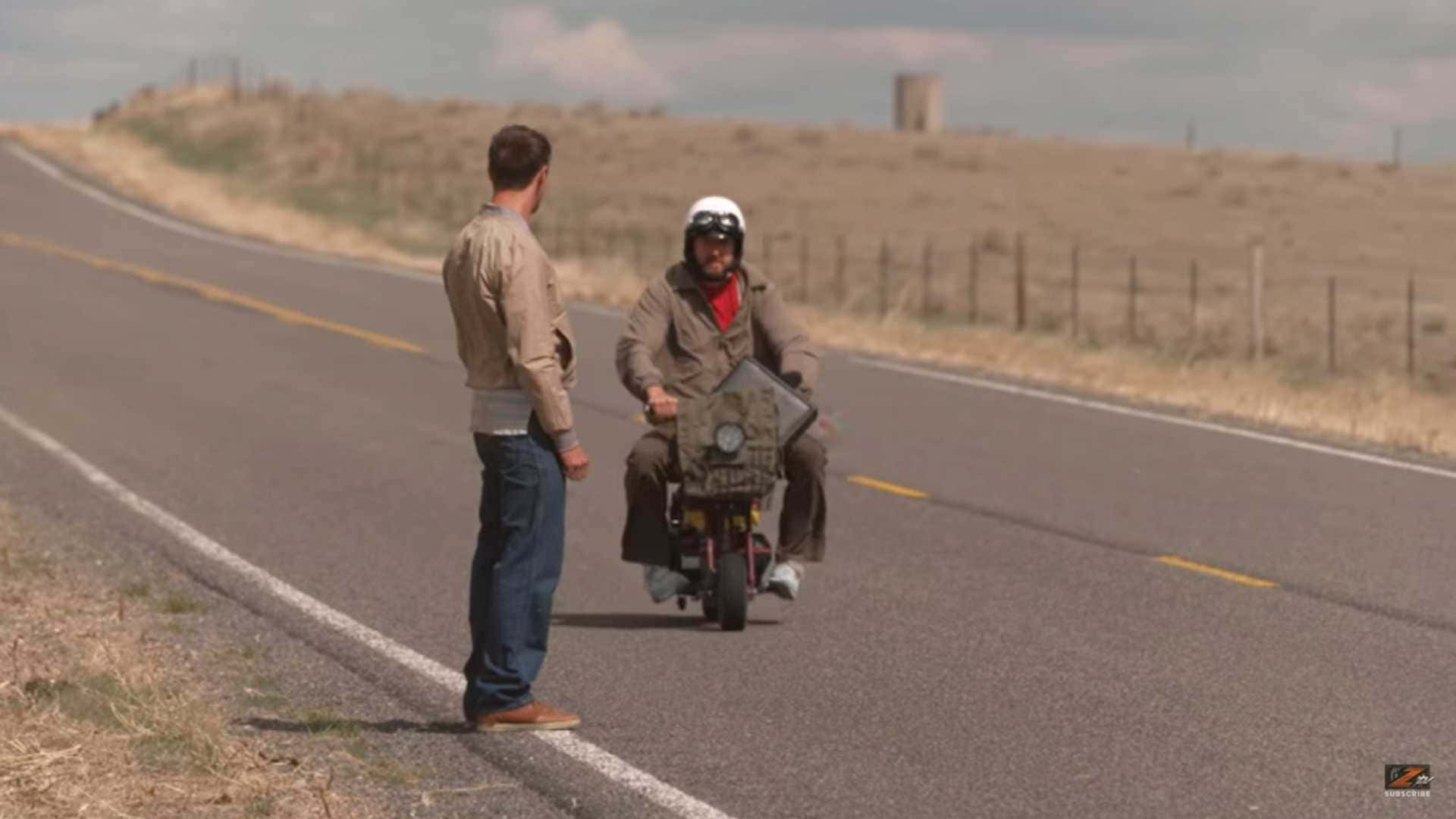 Unhombre En Una Motocicleta Está Hablando Con Otro Hombre En Una Carretera