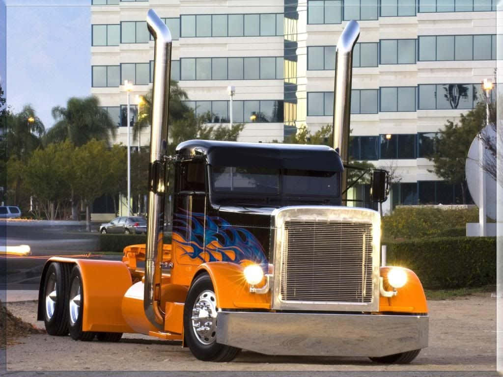 A Large Orange Semi Truck Parked In Front Of A Building