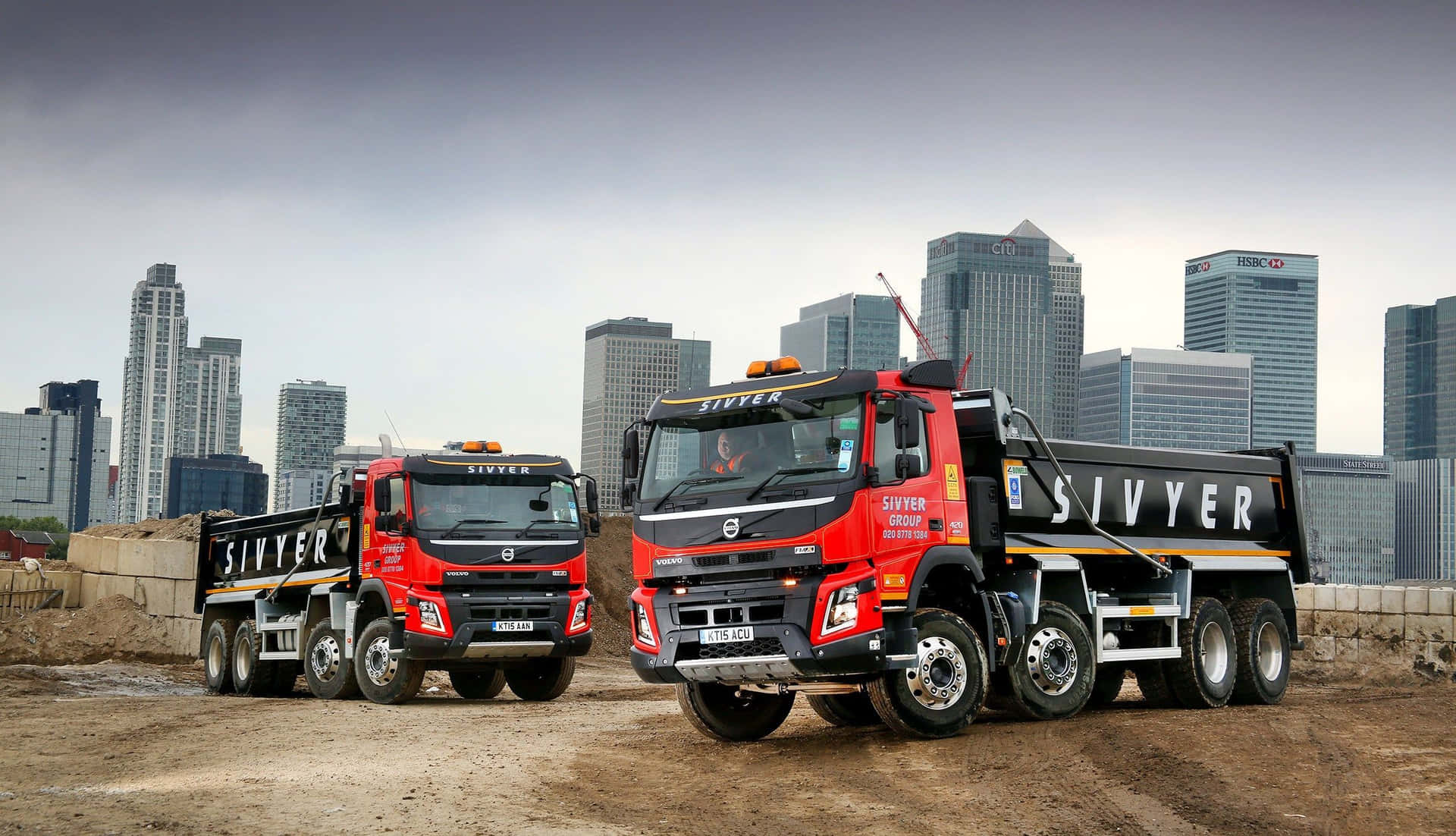 Two Trucks Parked In A Dirt Field