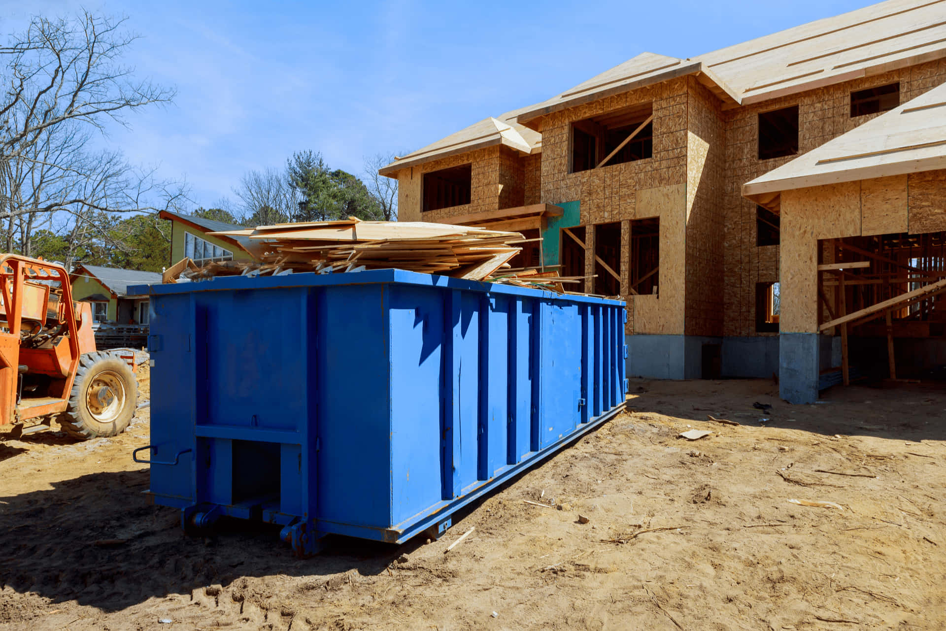 A Blue Dumpster In Front Of A House