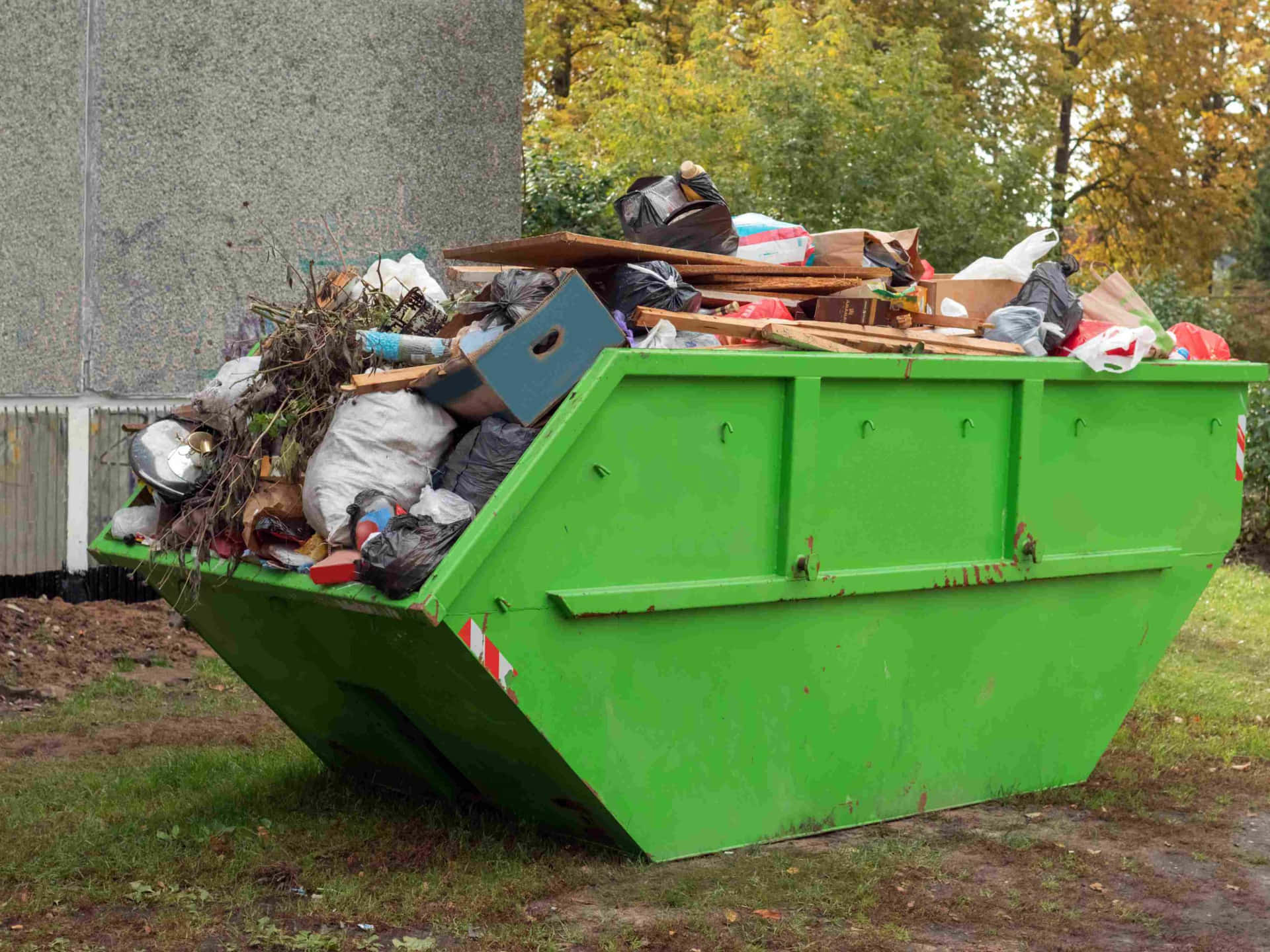 A Green Dumpster With A Lot Of Garbage