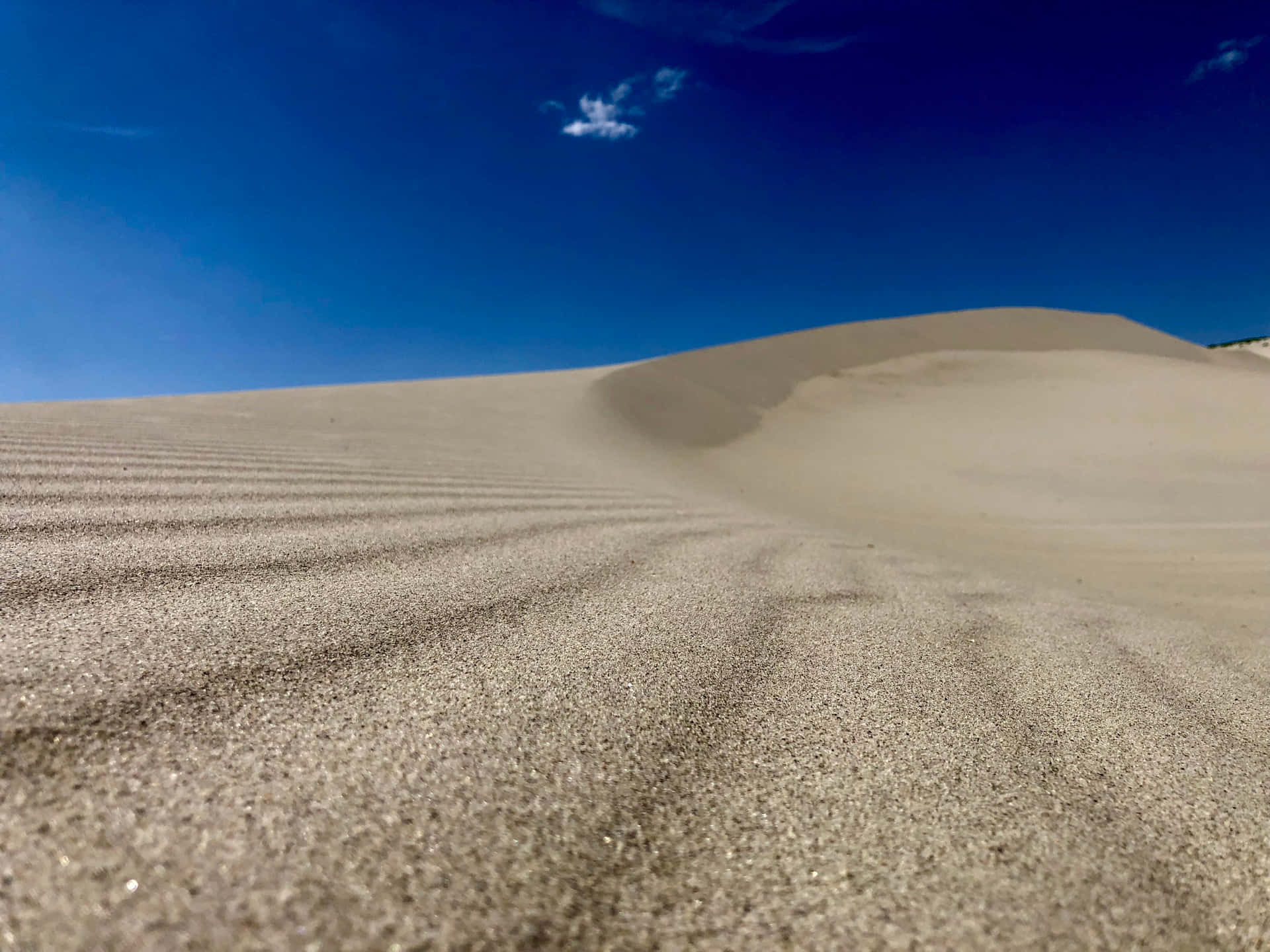 Download A Sand Dune With A Blue Sky And Clouds | Wallpapers.com