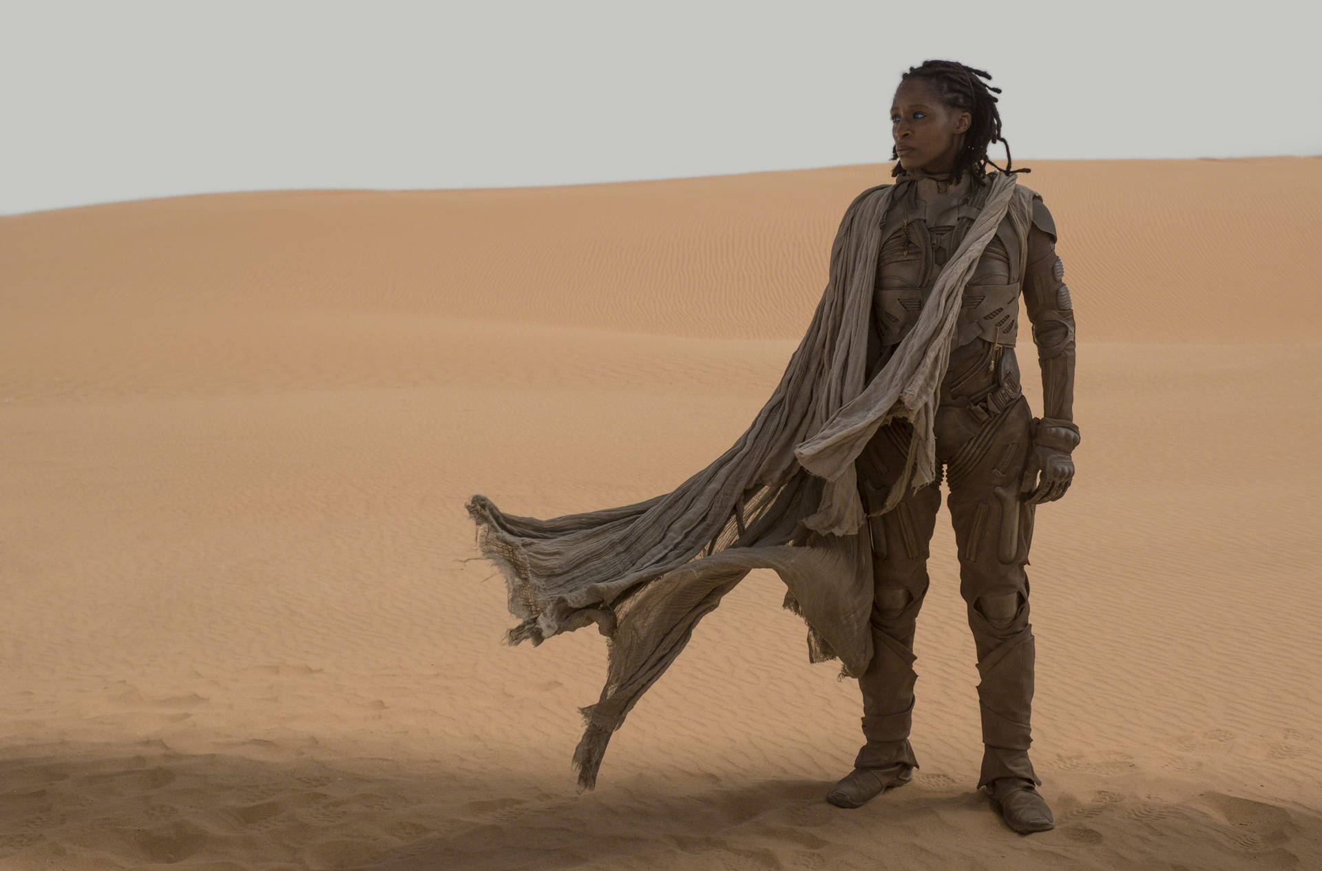 En mand i en kappe stående i ørkenen. Wallpaper