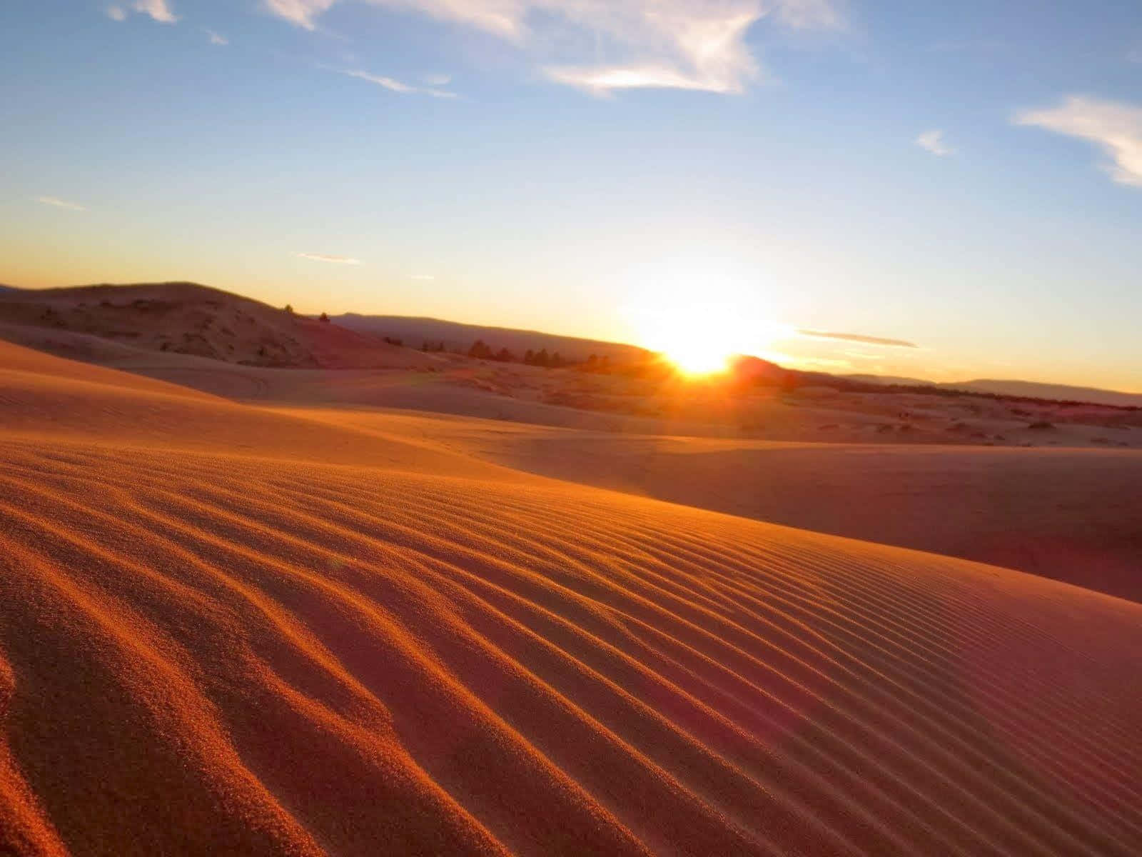 A Sunset Over A Sand Dune In The Desert