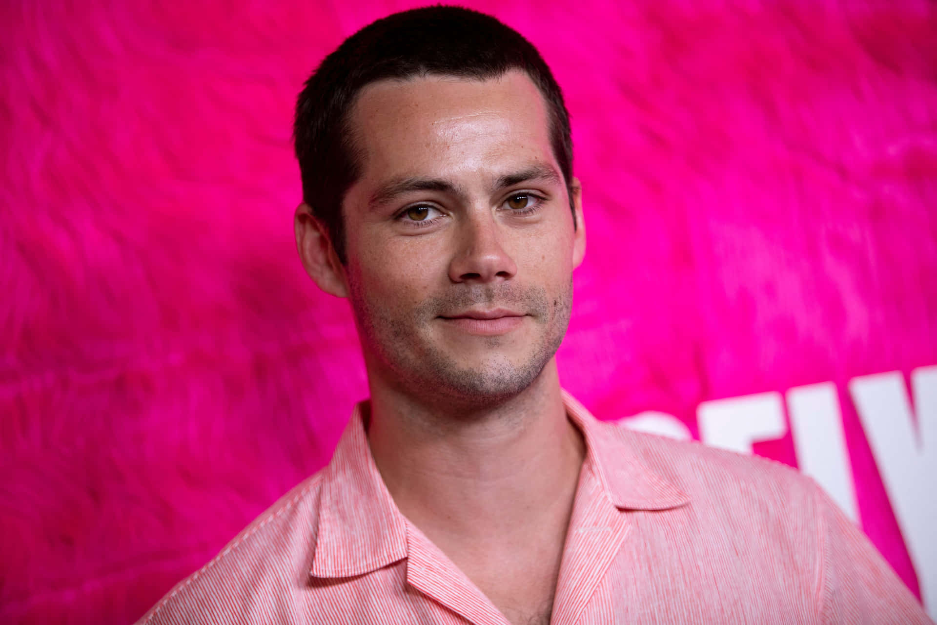 A Man In A Pink Shirt Is Posing For A Photo Wallpaper