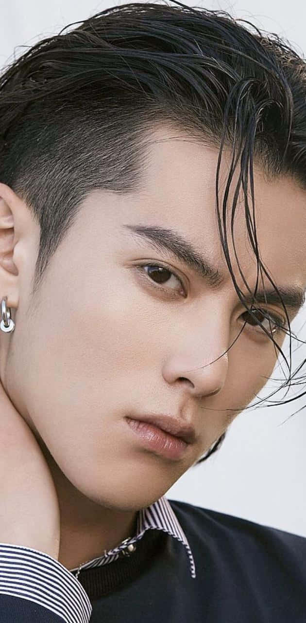 En ung mand med langt hår og en piercing i hans øre Wallpaper