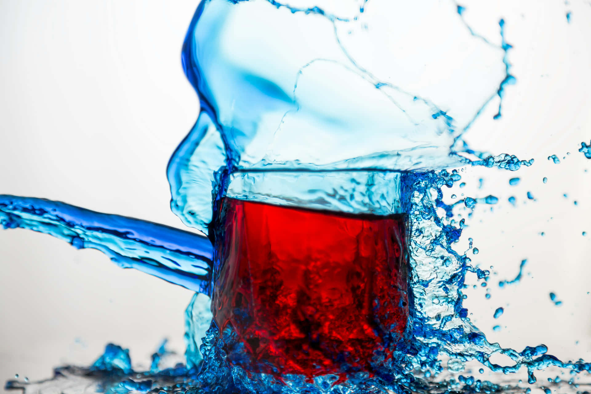 Dynamic Red Liquid Splashwith Blue Background Wallpaper
