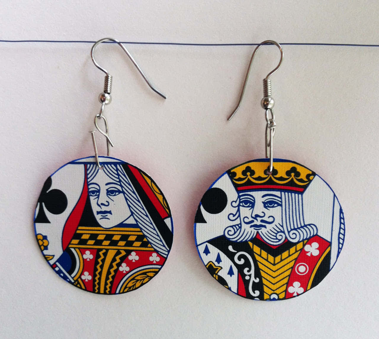 A Pair Of Earrings With A Queen And King On Them