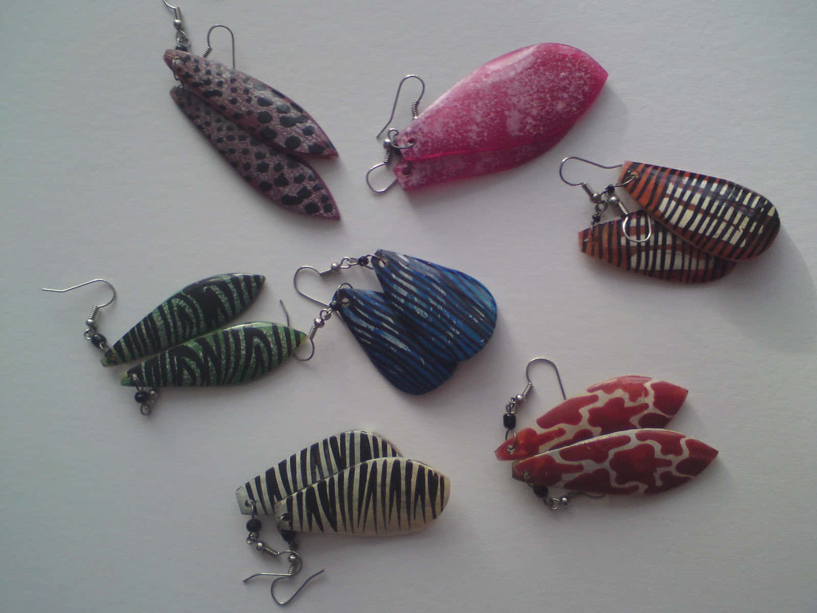 A Group Of Earrings With Different Colored Designs