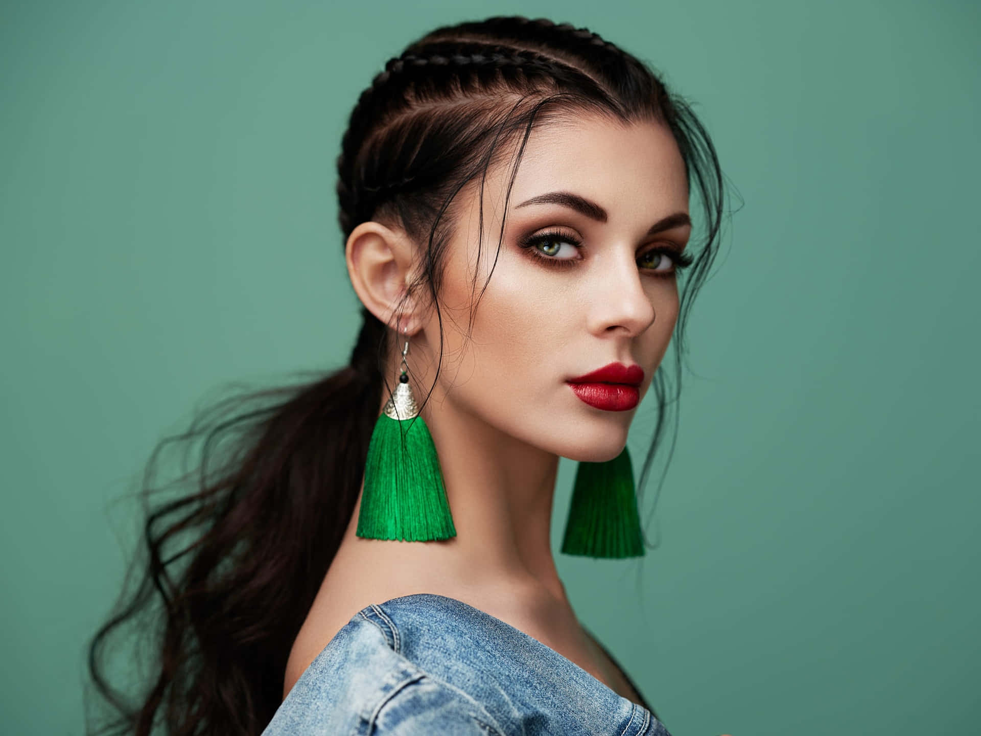 Beautiful Woman With Green Tassel Earrings Posing On Green Background