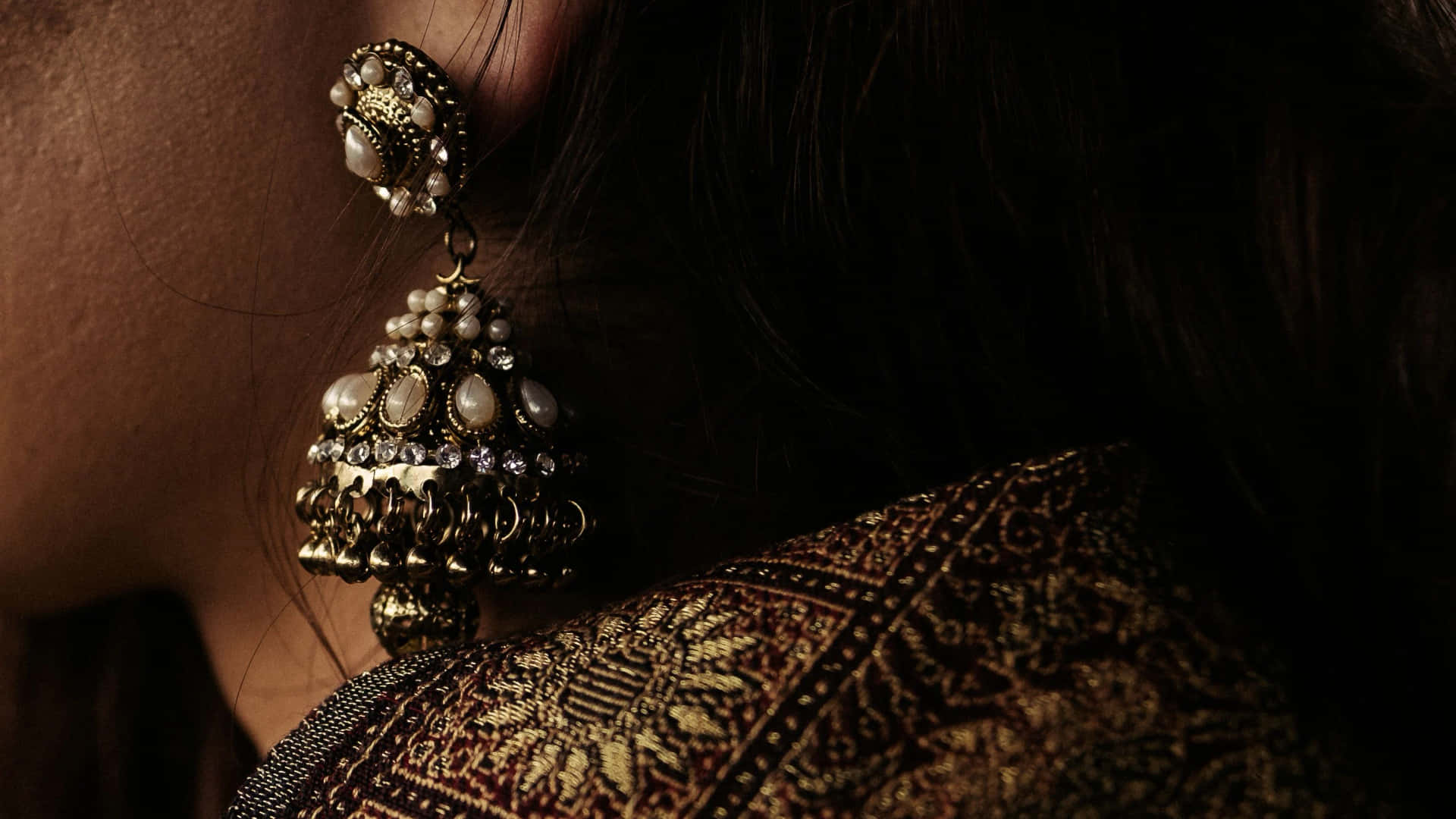 A Woman Wearing A Pair Of Earrings