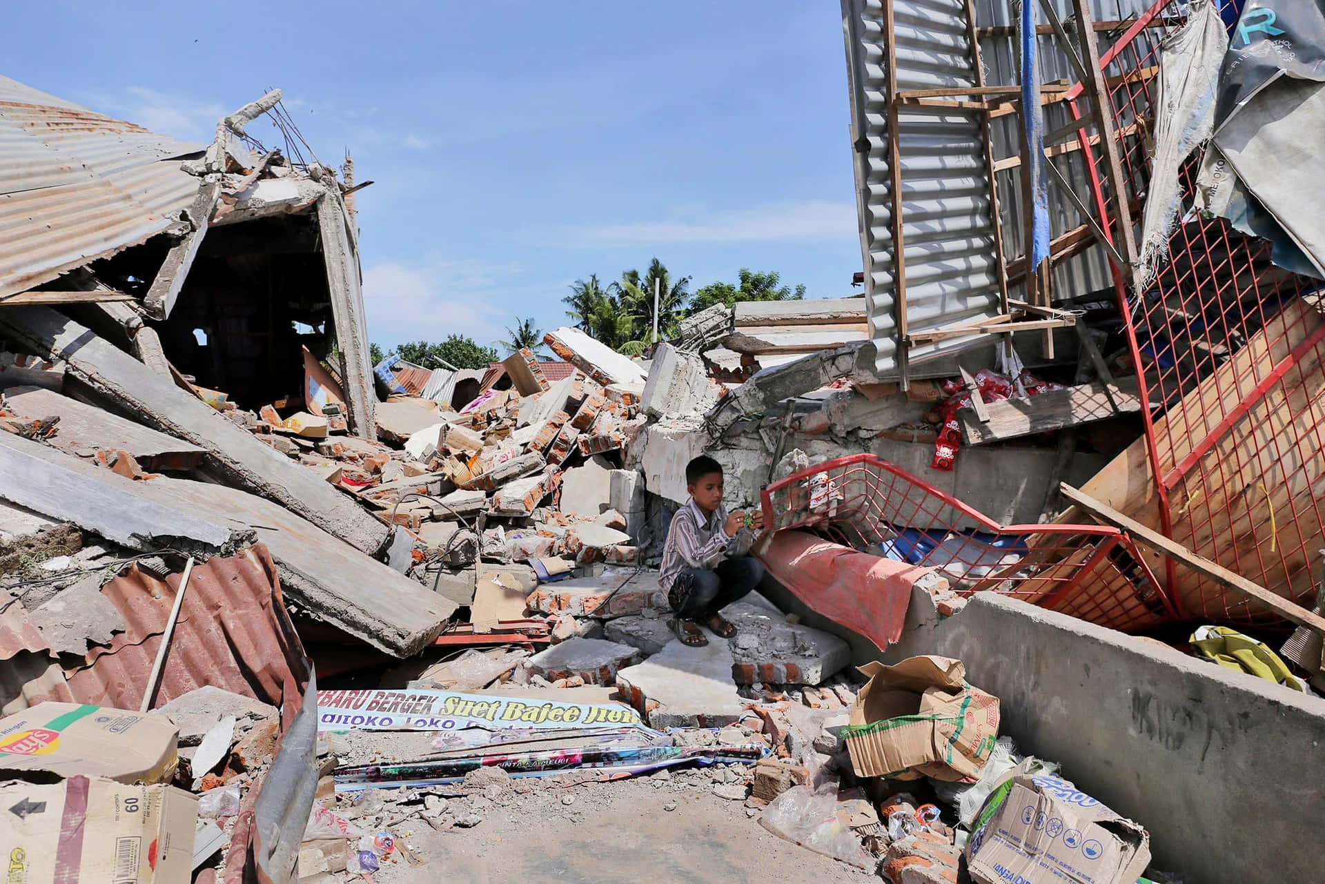 A Man Sits In The Rubble Of A Building