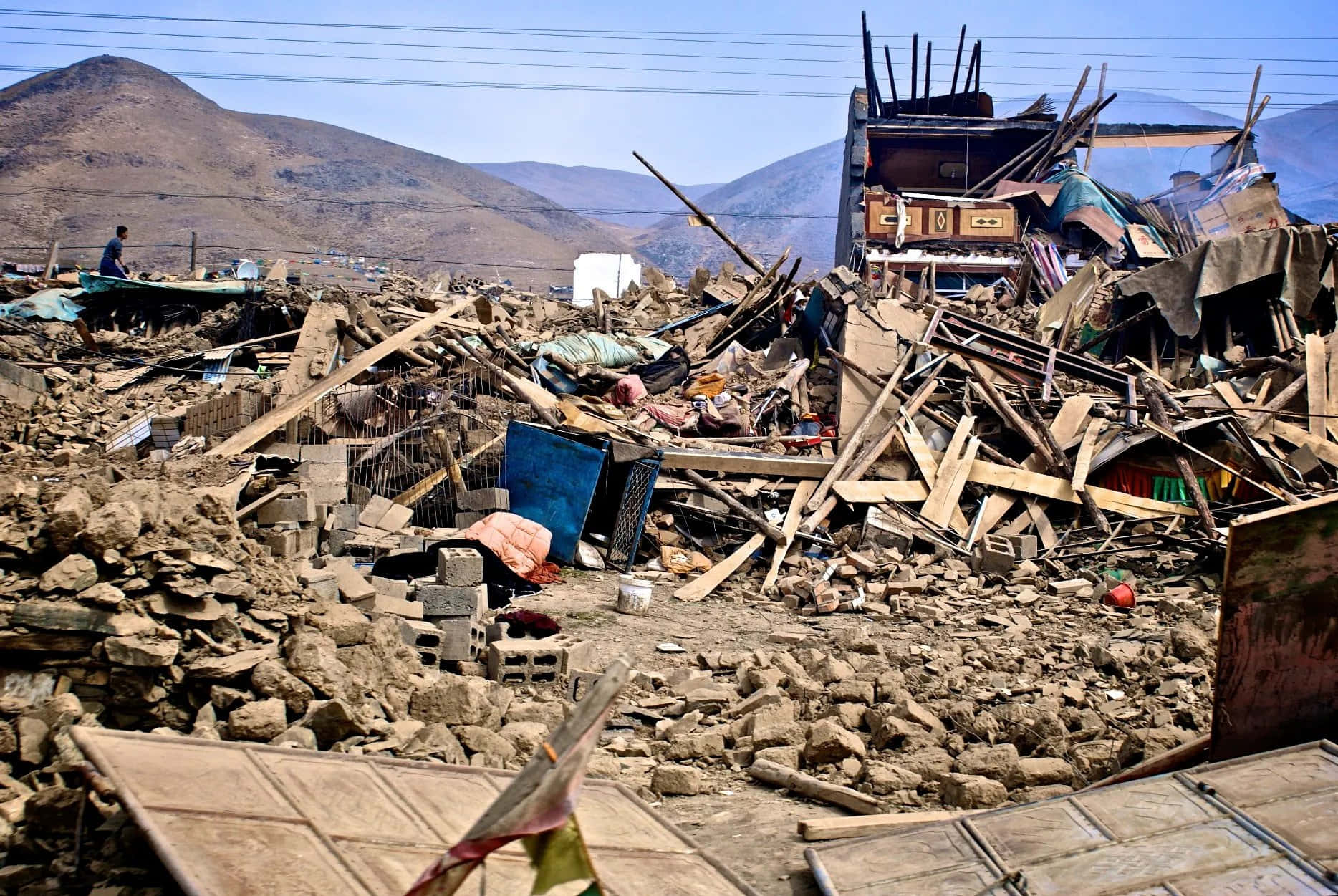 A Village With Debris And A Mountain In The Background