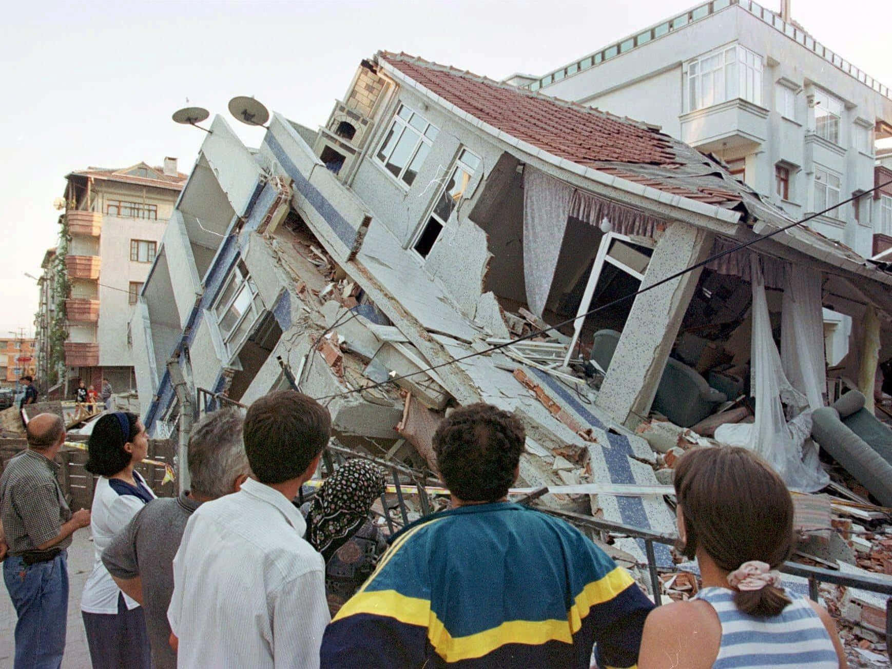 A Group Of People Standing Around A Building That Has Fallen Down