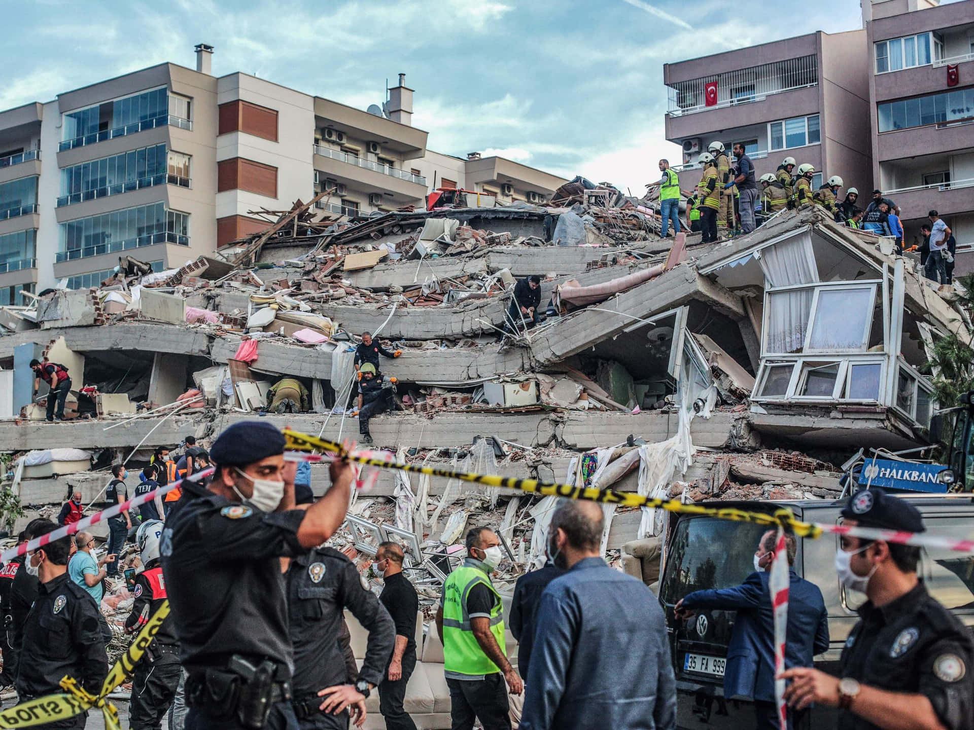 A Group Of People Standing Around A Building That Has Collapsed