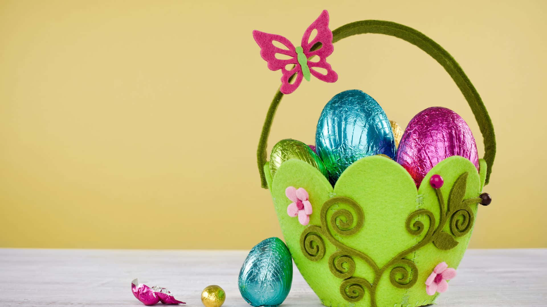 A festive and colorful Easter gift basket, complete with Easter eggs, candy and treats. Wallpaper