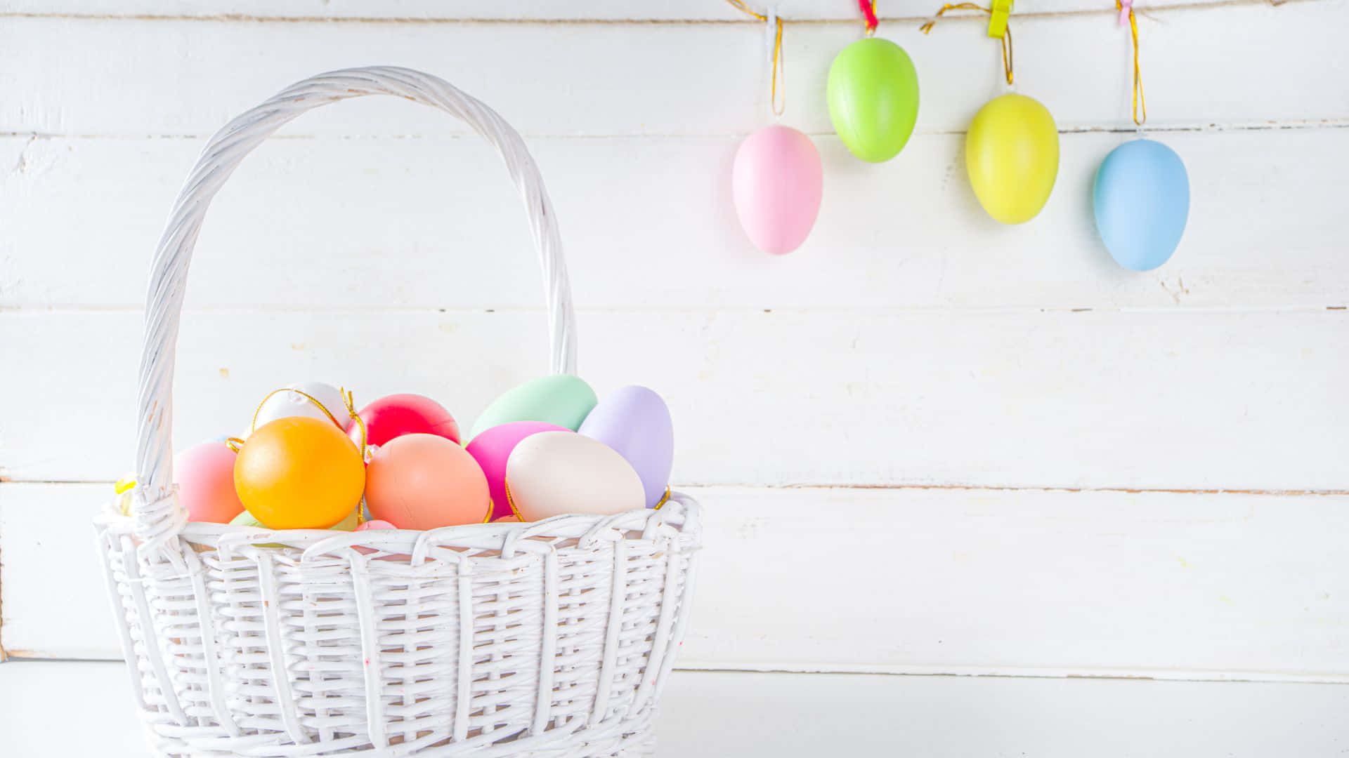 A Basket Filled With Colorful Easter Eggs Wallpaper