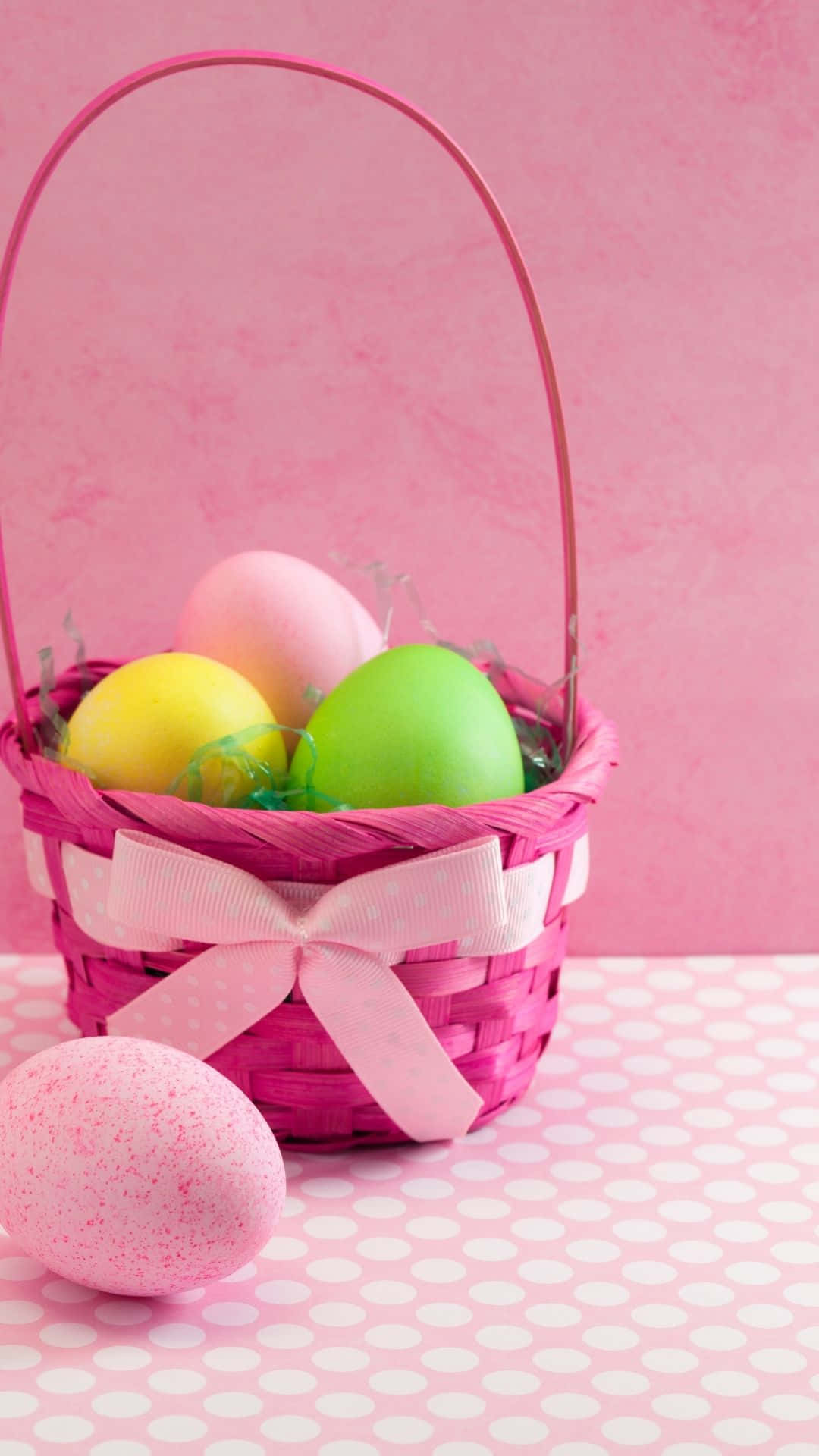 A festive Easter basket with brightly colored eggs and candy Wallpaper