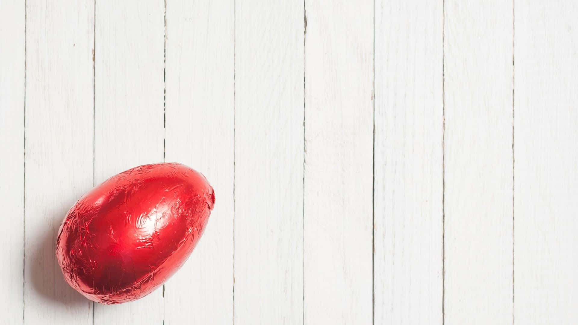 Unhermoso Huevo De Pascua En Un Diseño Pastel, Rodeado De Césped Verde Y Flores Rosadas Y Amarillas. Fondo de pantalla