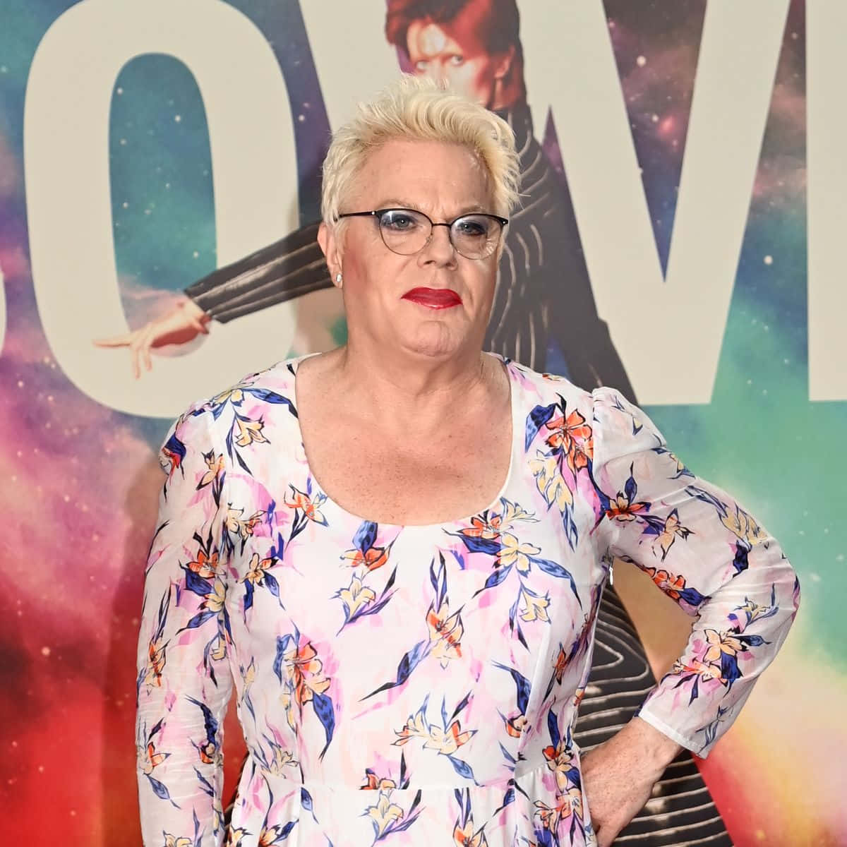 Eddie Izzard performing on stage in a vibrant outfit Wallpaper