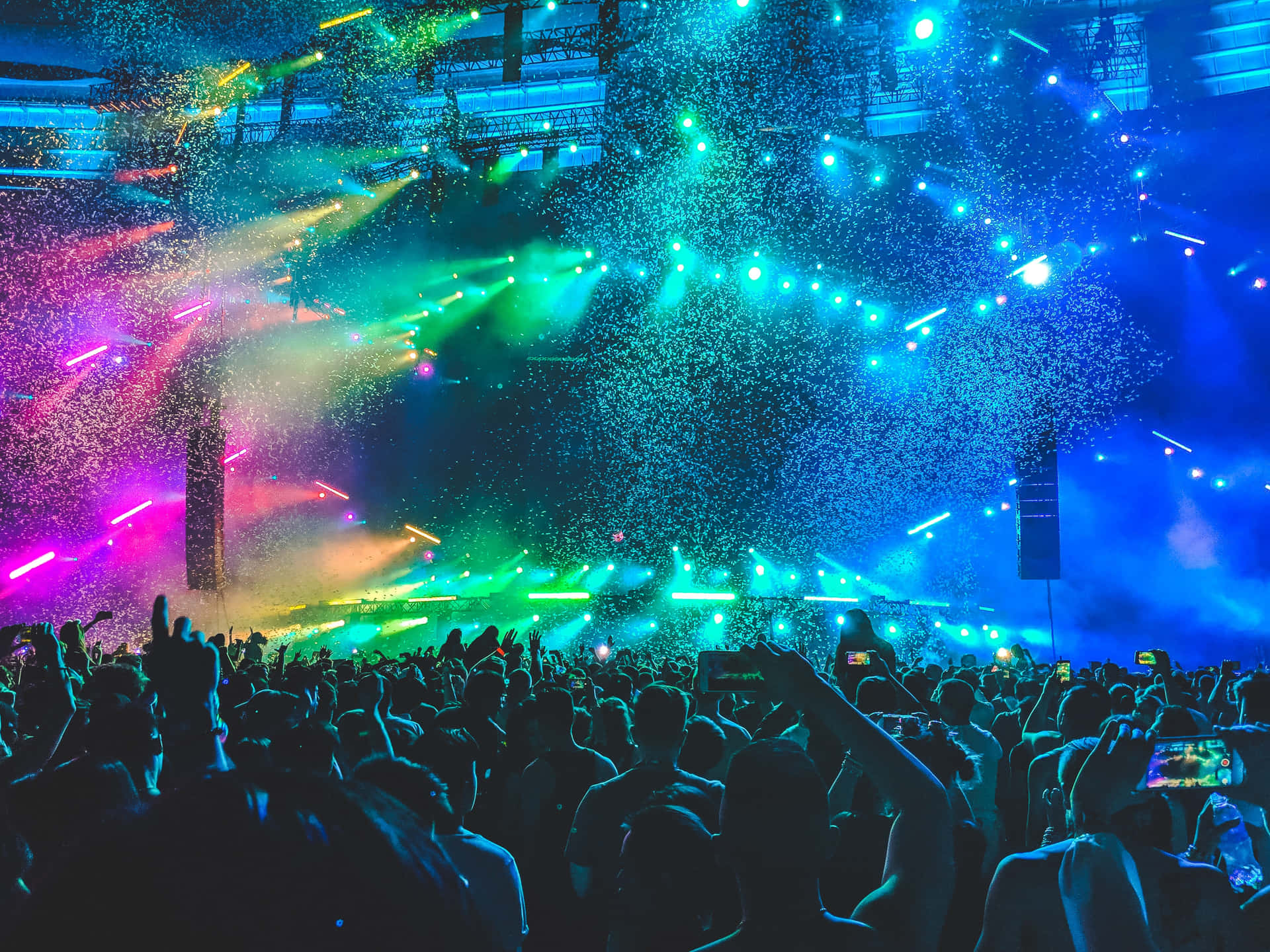 A Crowd At A Concert With Colorful Lights Wallpaper