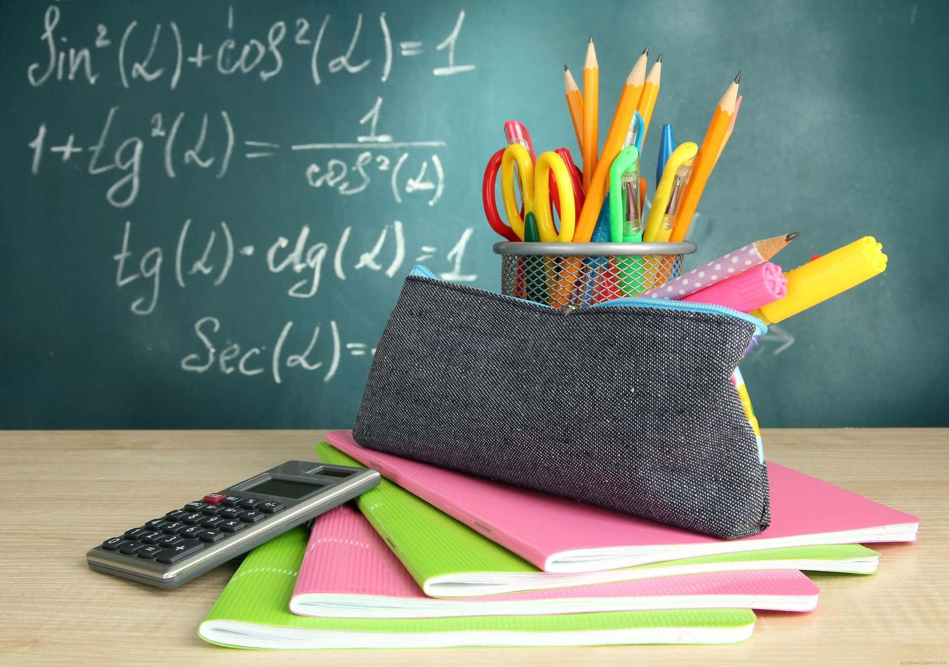 A Pencil Case With Pens And Pencils On A Blackboard