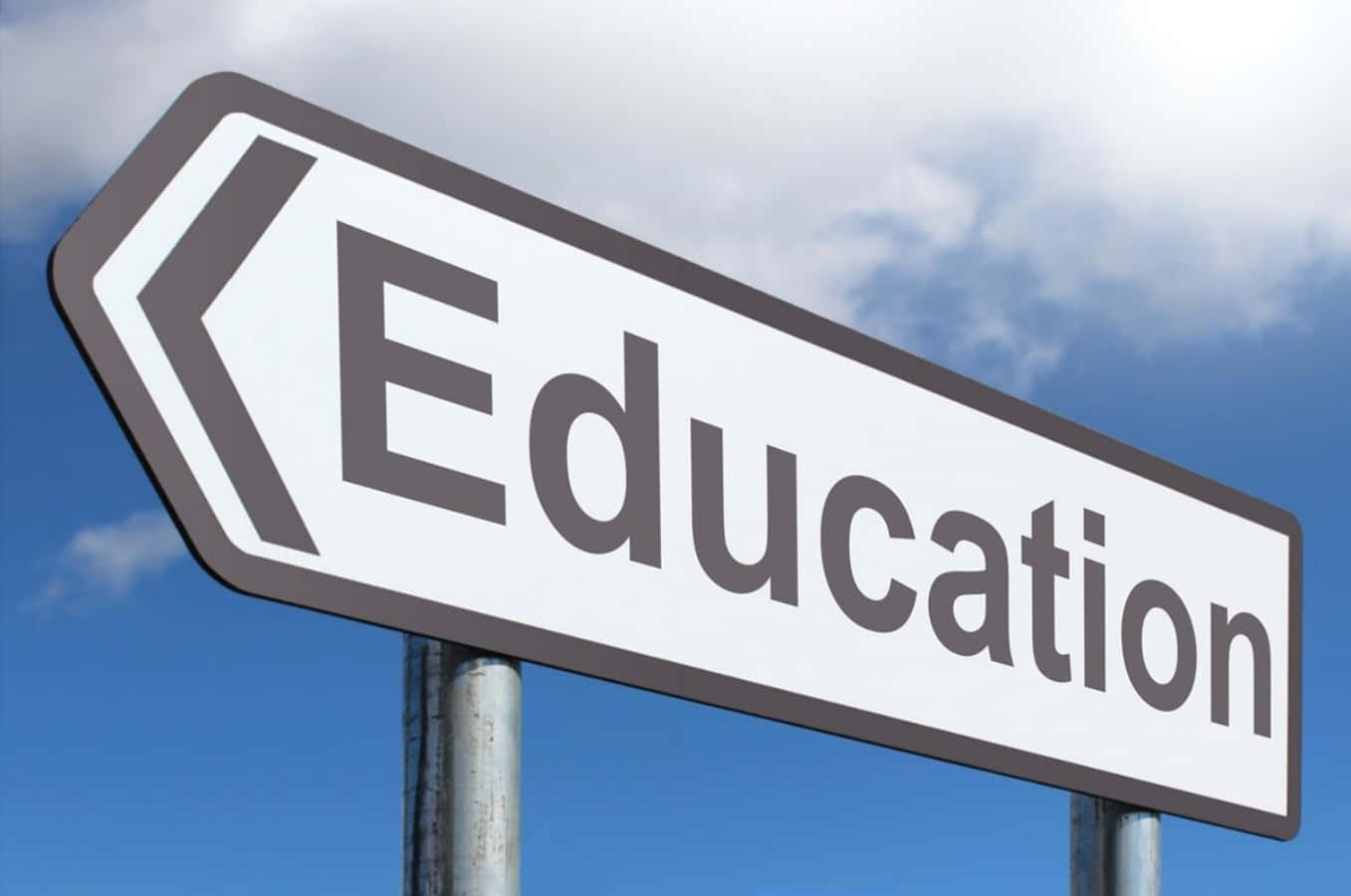 A White And Black Sign Pointing To Education